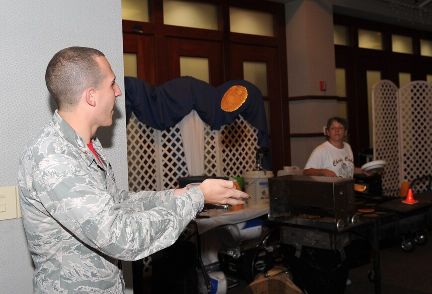 2nd Lt. Joseph Kraynak, 22nd Maintenance Squadron accessories flight commander, catches a pancake, Aug. 22, 2014, at McConnell Air Force Base, Kan. The pancake breakfast raised funds for the upcoming Air Force Ball, scheduled for Sep. 20. (U.S. Air Force photo/Airman 1st Class David Bernal Del Agua)
