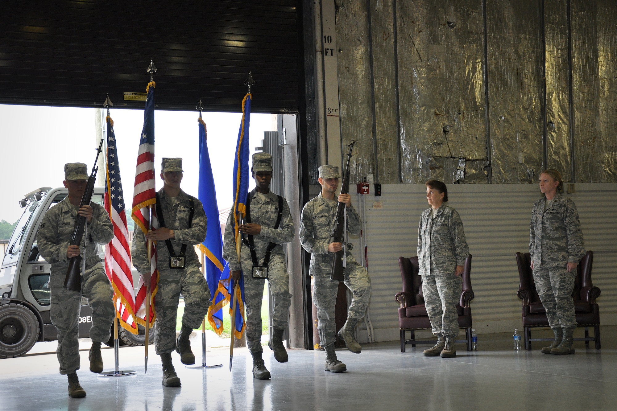 Maj. Kristin Brockshus, 916th Logistics Readiness Squadron commander, and Col. Karen Magnus, 916th Mission Support Group commander, stand at attention as Airmen from the 4th Fighter Wing Honor Guard prepare to present “The Colors” during the 916th LRS Assumption of Command ceremony, Aug. 2014. (U.S. Air Force photo by Staff Sgt. Alan Abernethy)