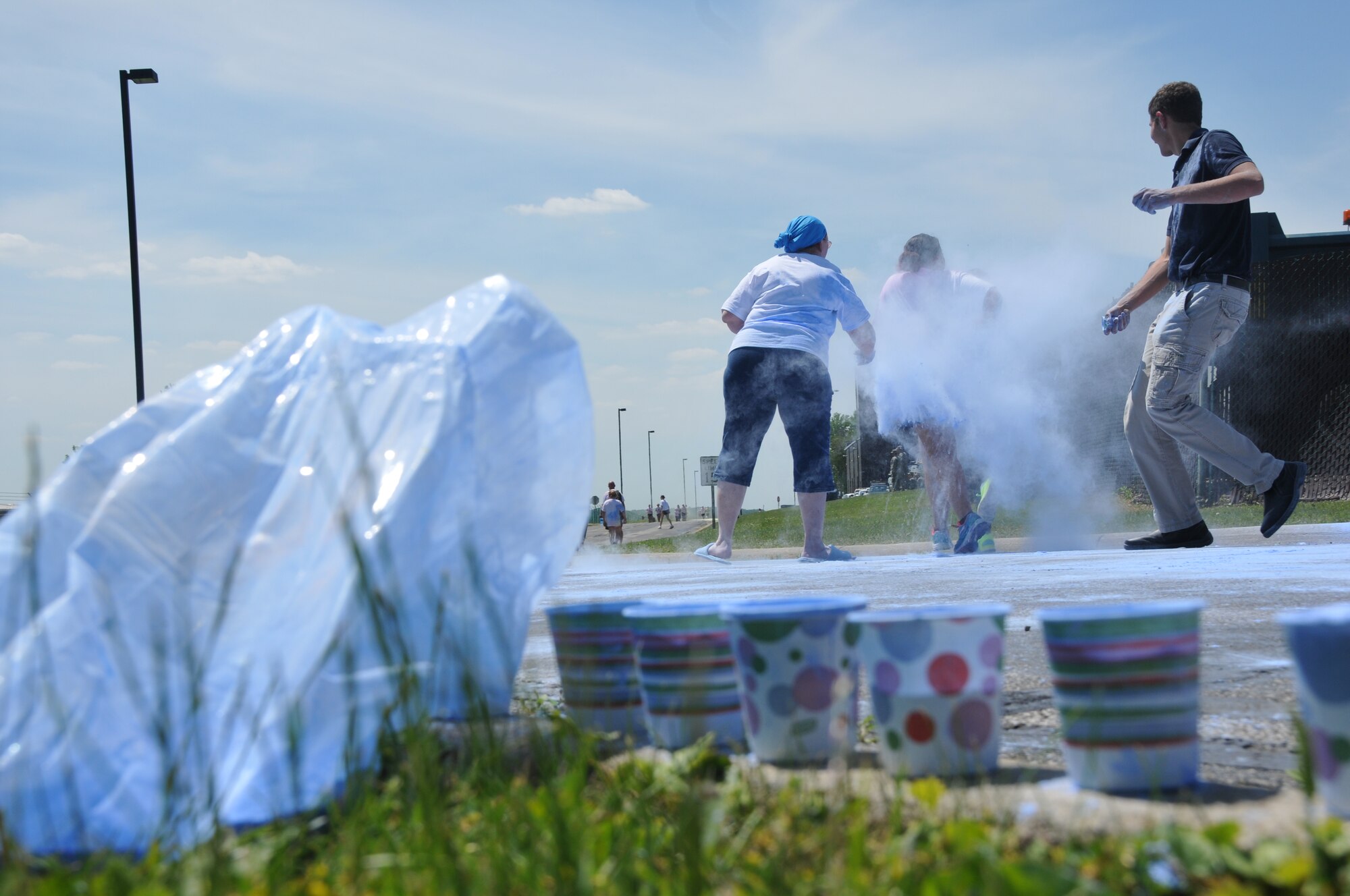 179th Airlift Wing members and their family members run through clouds of colored corn starch during the Color Fun 5k at the 179th Airlift Wing, Mansfield, OH, June 7, 2014. (U.S. Air National Guard Photo by TSgt Joseph Harwood \Released)