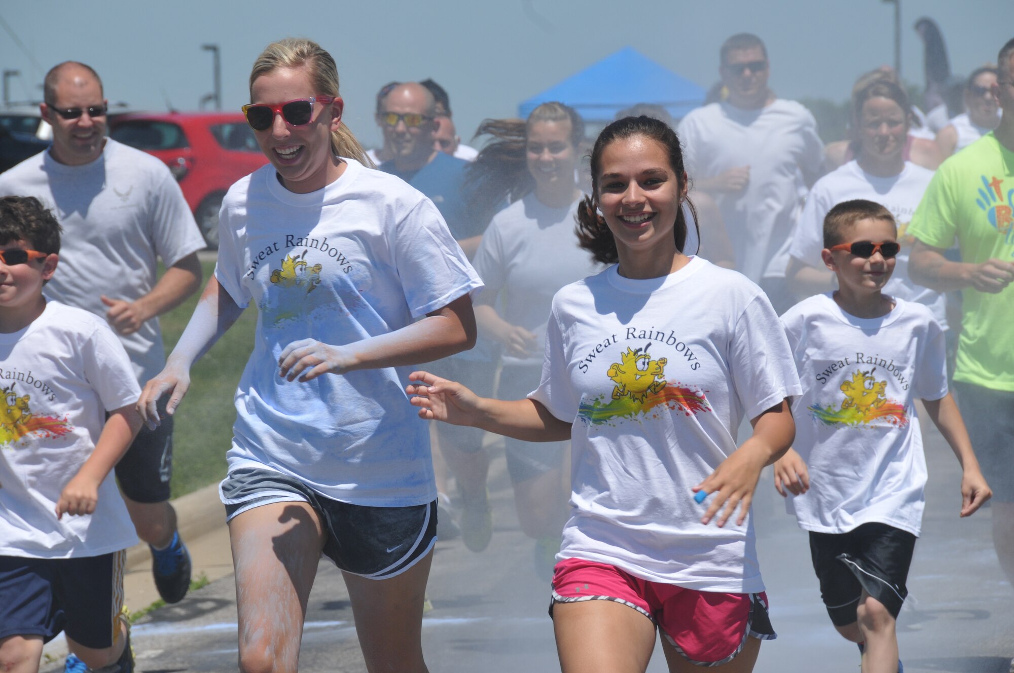 179th Airlift Wing members and their family members run through clouds of colored corn starch during the Color Fun 5k at the 179th Airlift Wing, Mansfield, OH, June 7, 2014. (U.S. Air National Guard Photo by TSgt Joseph Harwood \Released)
