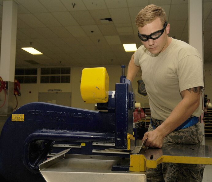 Staff Sgt. Casey Durham uses a lever shear to trim excess material that wasn’t able to be removed by the foot shear at Fairchild Air Force Base, Washington, Aug. 20, 2014. Part of Durham’s day-to- day work is accomplishing a full inspection of the tanker for preventative maintenance, evaluate damage and corrosion on the aircraft and paint and place decals. Durham is an aircraft structural craftsman from the 92nd Maintenance Squadron. (U.S. Air Force photo/Staff Sgt. Samantha Krolikowski)