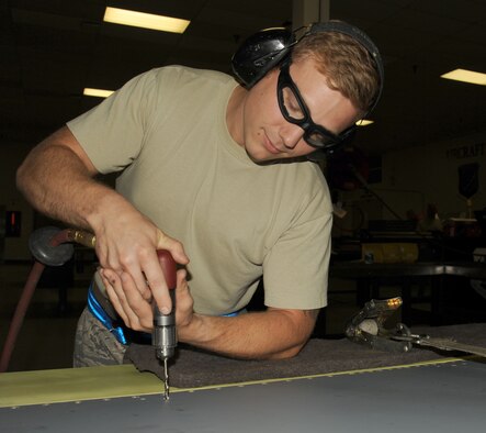 Staff Sgt. Casey Durham replaces the trailing edge of a flap from the KC-135 Stratotanker at Fairchild Air Force Base, Washington, Aug. 20, 2014. When the flaps are damaged or need replaced, a new trailing edge is drilled and installed for pivot installation. As an aircraft structural craftsman, Durham evaluates damage and corrosion of the tanker and repairs it. Durham is an aircraft structural craftsman from the 92nd Maintenance Squadron. (U.S. Air Force photo/Staff Sgt. Samantha Krolikowski)