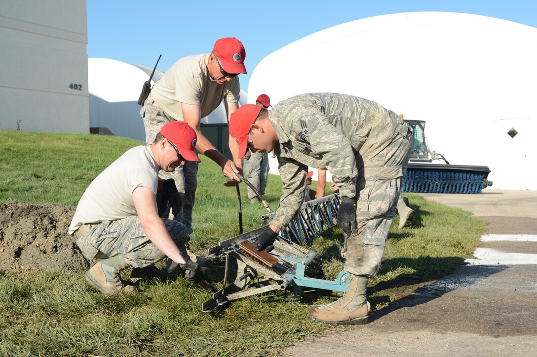 Airmen from the 210th Red Horse Squadron out of Kirtland Air Force Base, New Mexico, clean their equipment following a concrete project at the 115th Fighter Wing in Madison, Wis., Aug. 14, 2014. The group temporarily deployed to the 115 FW to complete various infrastructure projects on the base, while gaining real-world experience. (Air National Guard photo by Senior Airman Andrea F. Liechti)