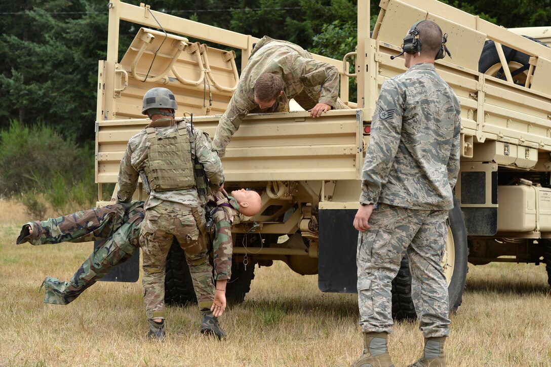 Senior Airman Dominic Lee (left), 5th Air Support Operations Squadron tactical air control party member, hoists a dummy onto a truck to Airman 1st Class Joseph Pennington, 5th ASOS TACP member, Aug. 20, 2014, during the Cascade Challenge at Range 103 next to North Fort Lewis at Joint Base Lewis-McChord, Wash. During the first half of the event, the participants were required to drag a 180 pound dummy before firing the Beretta M-9 pistol. (U.S. Air Force photo/Airman 1st Class Keoni Chavarria)