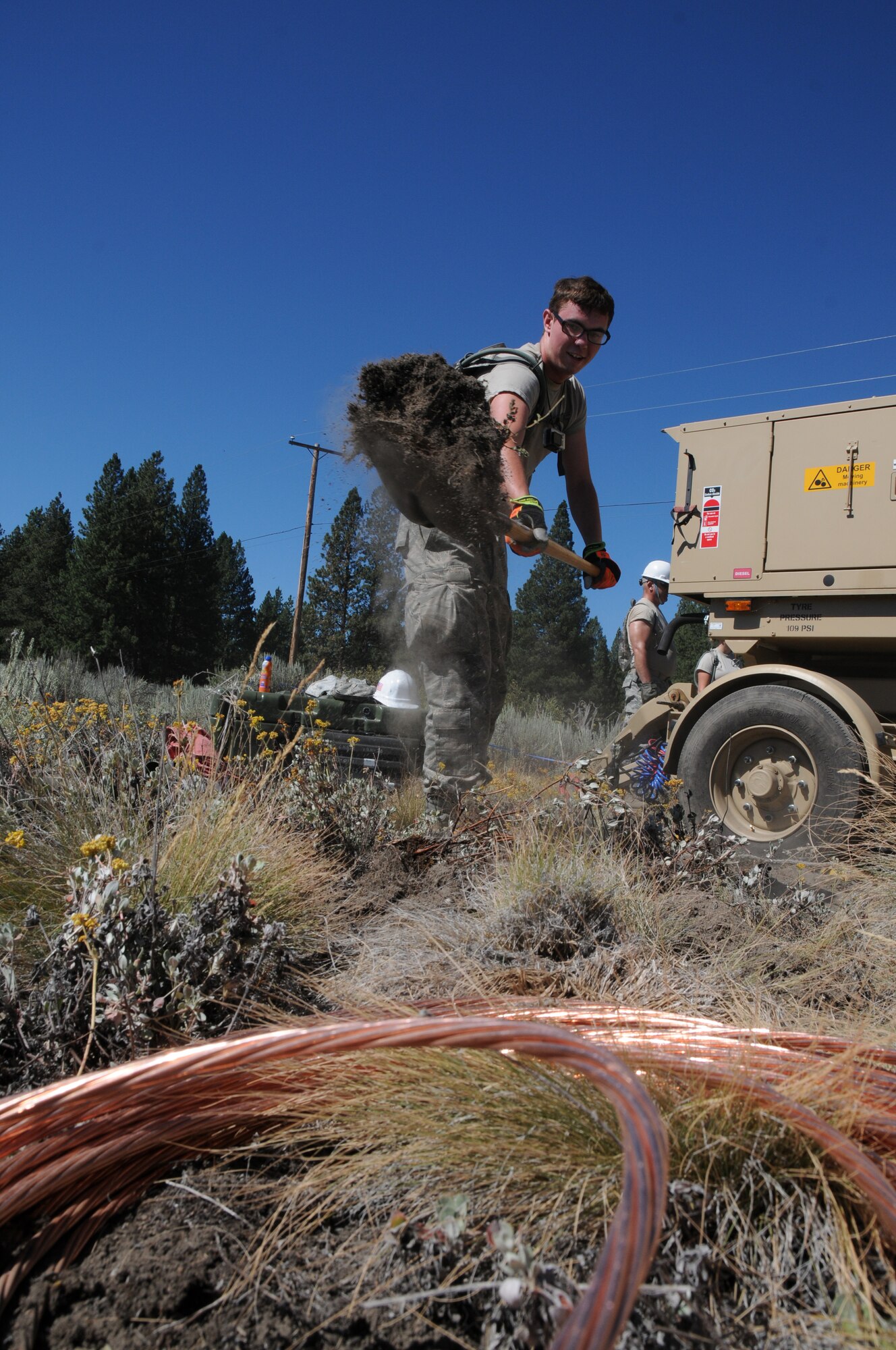 U.S. Air Force Airman 1st Class Joshua Scruggs, 270th Air Traffic Control Squadron, digs a hole for the grounding system designed to protect the TRN-48 Tactical Air Navigation Aid from lighting strikes by conducting the tremendous amount of electrical energy into the earth and around vital components. The 270th ATCS controls the airspace for the 173rd Fighter Wing as well as civilian aircraft at Kingsley Field but also has an expeditionary tasking. This year’s annual training emphasized that capability and involved several exercises off base. (U.S. Air National Guard photo by Tech. Sgt. Jefferson Thompson/Released)