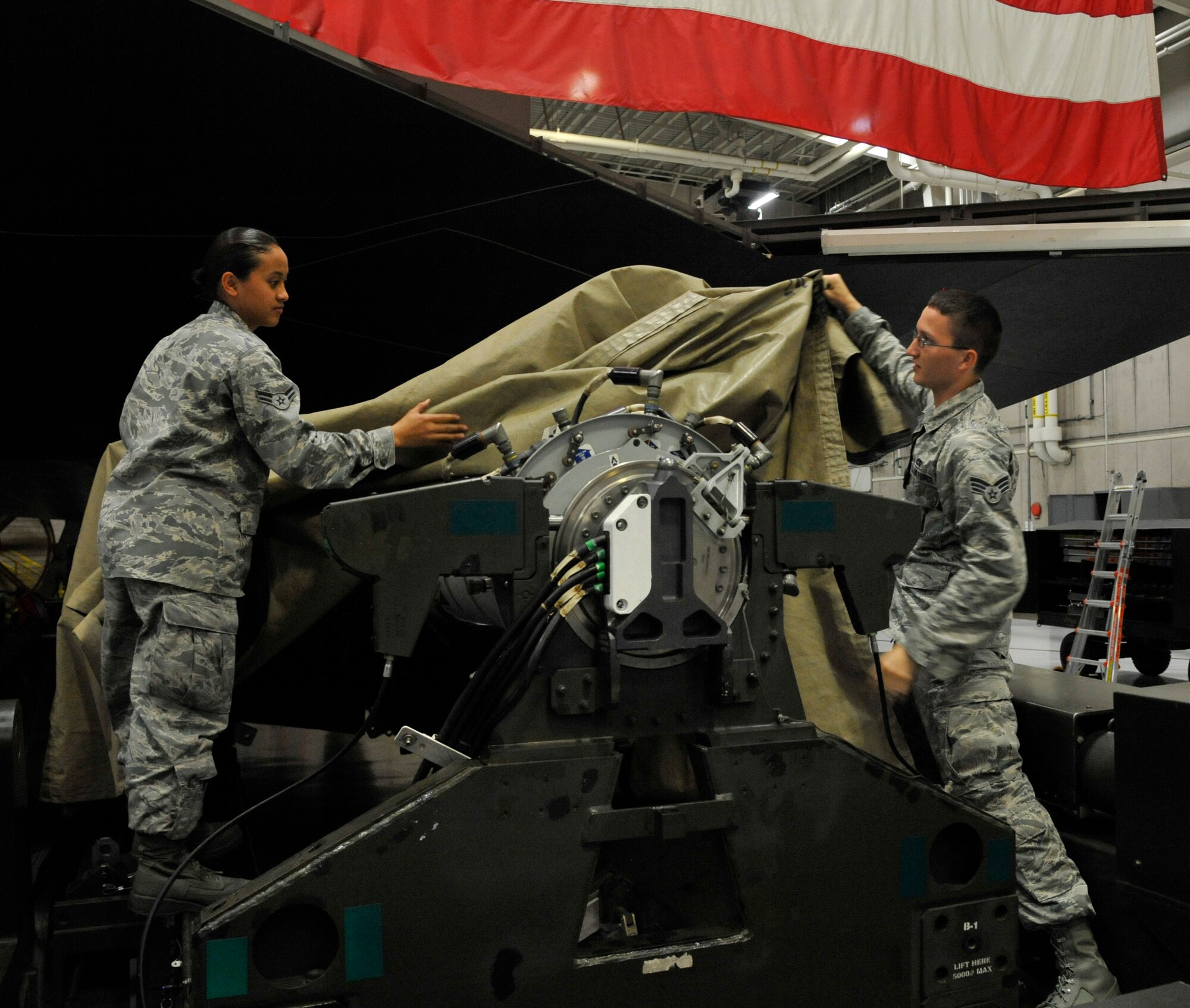 U.S. Air Force Airman 1st Class Nicole Almario, 509th Aircraft Maintenance Squadron weapons load member, left, and Senior Airman Timothy McKinnon, 509th AMXS weapons load member, removes tarp from a 204 trailer at Whiteman Air Force Base, Missouri, Aug. 11, 2014. The 509th AMXS weapons load crew are preparing for the 2014 Global Strike Challenge. In 2012, the 509th Bomb Wing won the Fairchild Trophy for “Best Bomb Wing." (U.S. Air Force photo by Airman 1st Class Keenan Berry/Released)