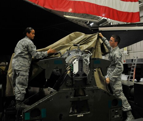 U.S. Air Force Airman 1st Class Nicole Almario, 509th Aircraft Maintenance Squadron weapons load member, left, and Senior Airman Timothy McKinnon, 509th AMXS weapons load member, removes tarp from a 204 trailer at Whiteman Air Force Base, Missouri, Aug. 11, 2014. The 509th AMXS weapons load crew are preparing for the 2014 Global Strike Challenge. In 2012, the 509th Bomb Wing won the Fairchild Trophy for “Best Bomb Wing." (U.S. Air Force photo by Airman 1st Class Keenan Berry/Released)