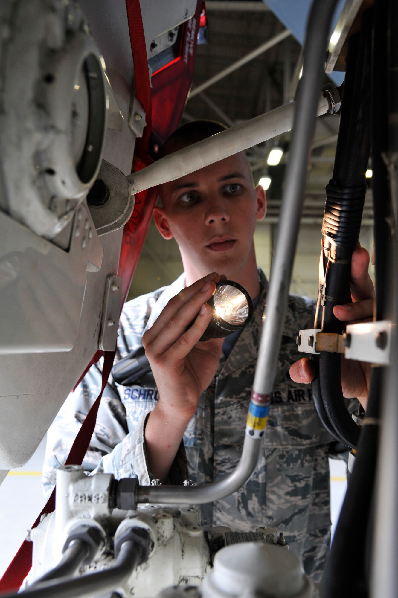 U.S. Air Force Staff Sgt. Brian Schroeder, 509th Aircraft Maintenance Squadron crew chief, inspects electrical hydraulic lines during his team's Global Strike Challenge 2014 practice, Aug. 15, 2014 at Whiteman Air Force Base, Missouri. During the challenge, Team Whiteman’s load crew members will be graded on their proficiency in several different functional areas including timeliness, reliability, safety, and order errors. (U.S. Air Force photo by Airman 1st Class Keenan Berry/Released)