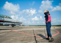 Airman 1st Class Clifford Bould, 96th Aircraft Maintenance Squadron, signals to an F-16 Fighting Falcon pilot after a final inspection from the end-of-runway crew at Eglin Air Force Base, Fla., Aug. 7.  The 96th Maintenance Group’s EOR crew is responsible for checking each aircraft for leaks, loose parts or any damage to the tires or aircraft before takeoffs and landings. (U.S. Air Force photo/Tech. Sgt. Jasmin Taylor)