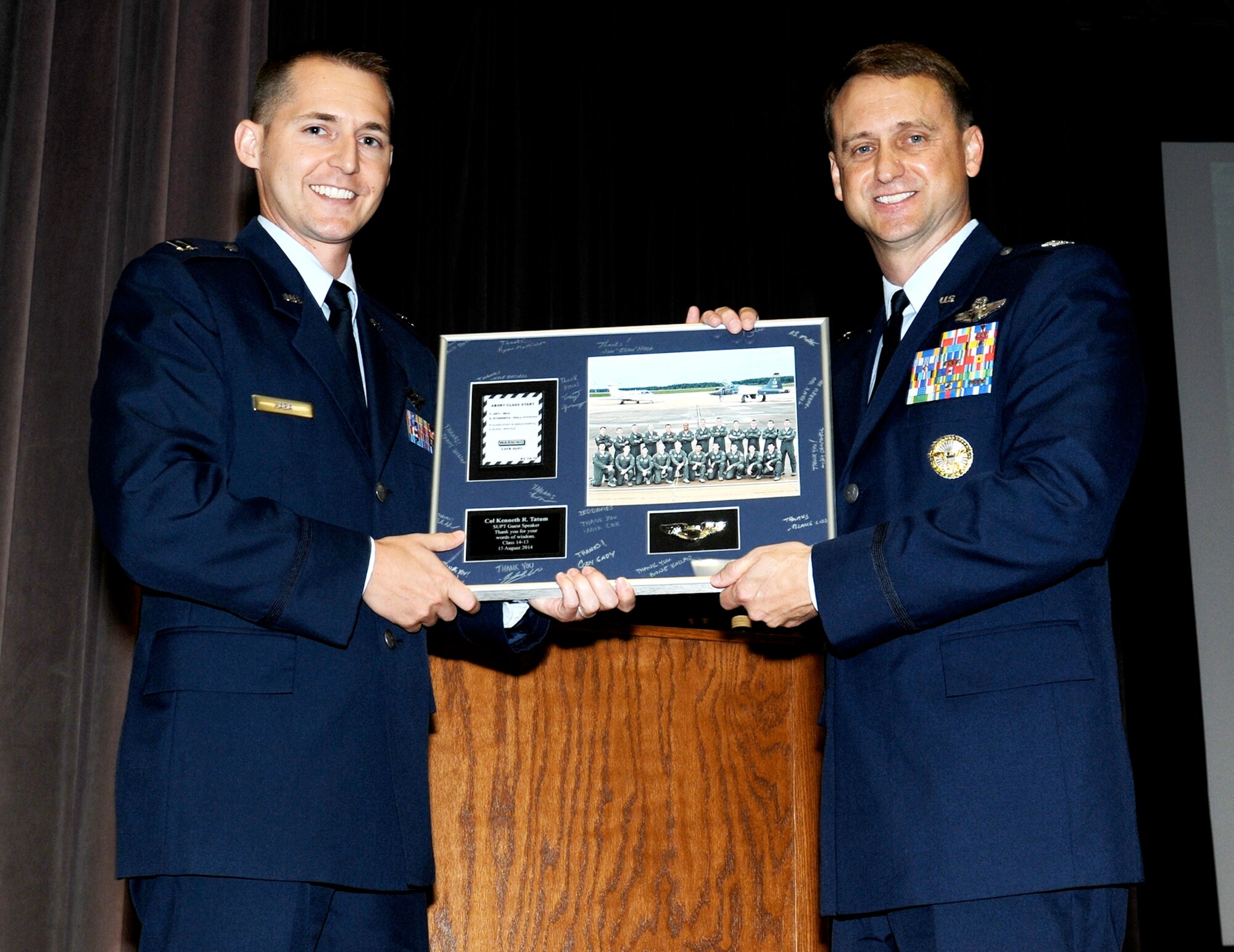 Capt. Jonathon Haba, Specialized Undergraduate Pilot Training class 14-13 senior ranking officer, hands a lithograph to Col. Kenneth Tatum, Commander of the Ira C. Eaker Center for Professional Development at Air University, Maxwell-Gunter Air Force Base, as a gift for being the guest speaker for the graduation. (U.S. Air Force photo/ Melissa Doublin)  