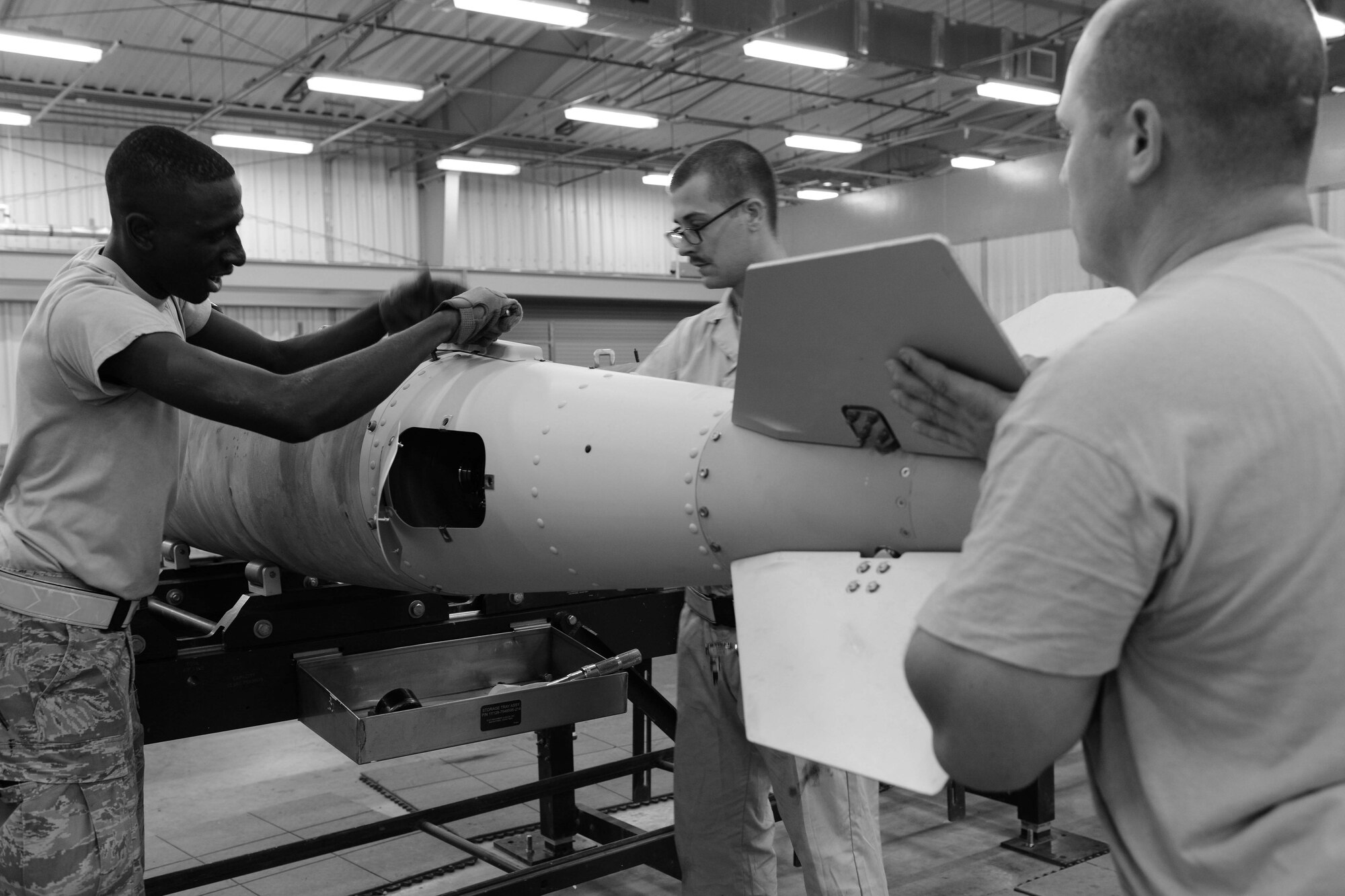 U.S. Air Force Airmen assigned to the 379th Expeditionary Maintenance Squadron conventional maintenance section load a fin onto a guided bomb unit at Al Udeid Air Base, Qatar, Aug. 20, 2014. The fin is one of the final steps when completing the build of a GBU. (U.S. Air Force photo by Staff Sgt. Ciara Wymbs)