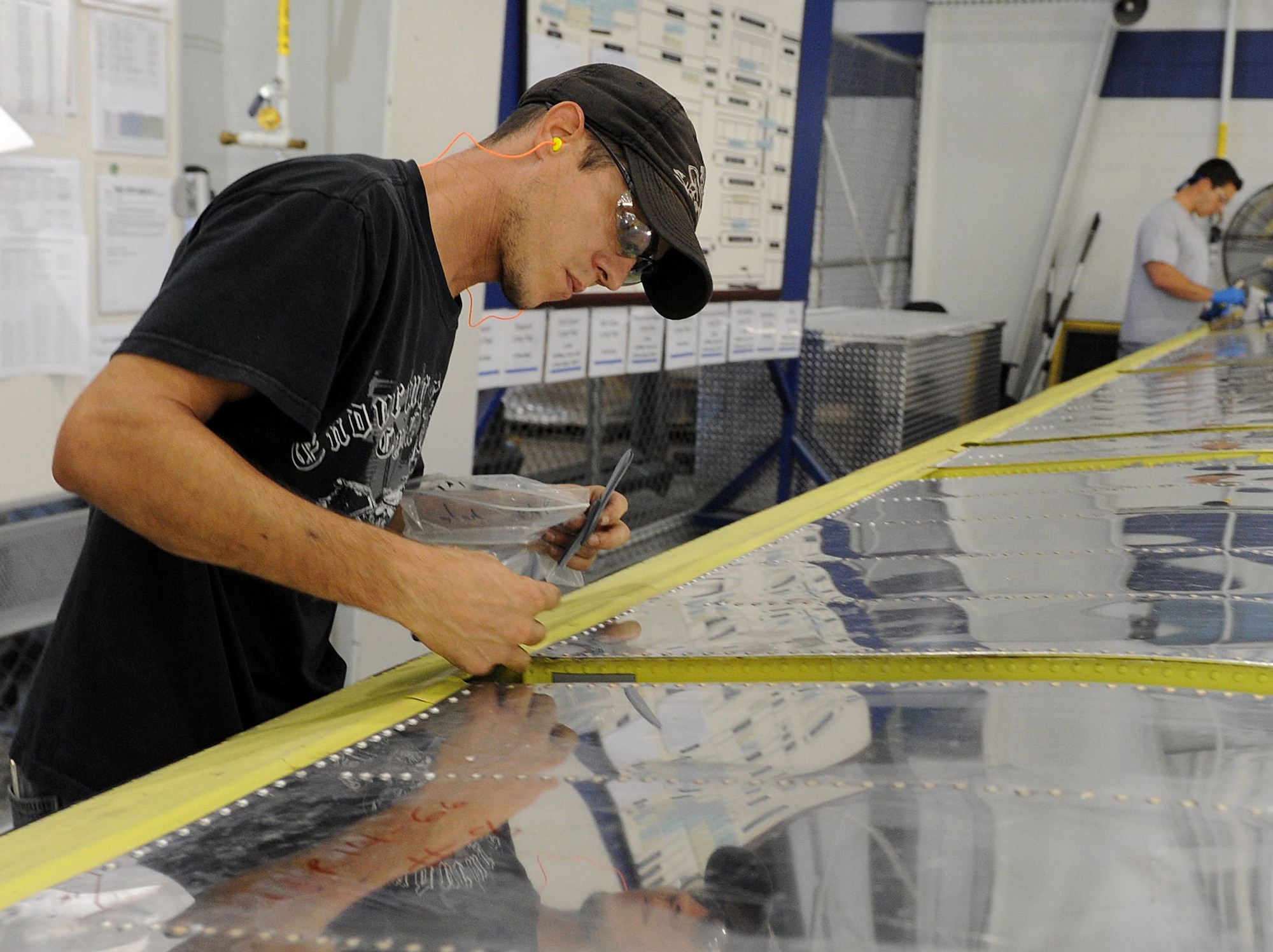 Eric Gason, 574th Commodities Maintenance Squadron aircraft sheet metal mechanic, works on a C-130 long flap at the shop’s table build-up gate. The organization has implemented process improvements that have increased flap production to three sets per month with plans for even further increases. (U.S. Air Force photo by Tommie Horton)