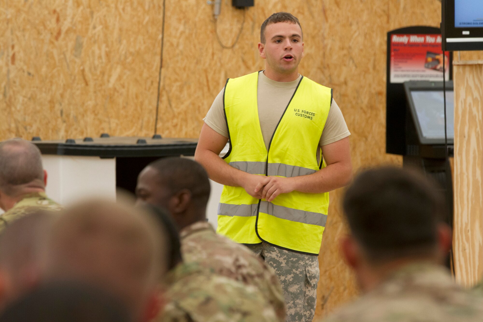 Pvt. Brahim El Idrissi, a military police officer working in U.S. Forces Customs, briefs Soldiers and Marines redeploying Aug. 12, 2014 from Afghanistan back to the United States through Mihail Kogalniceanu Air Base, Romania. El Idrissi, of Cranston, R.I., is attached to the 202nd Military Police Company based out of Fort Bliss, Texas. (U.S. Army photo by Sgt. Brandon Hubbard, 21st TSC, USAREUR)