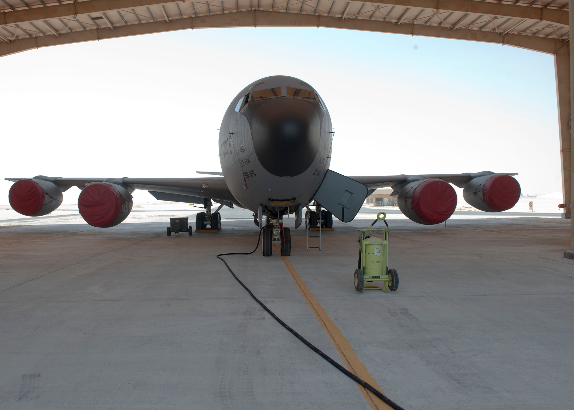A KC-135 Stratotanker sits underneath a newly constructed awning at Al Udeid Air Base, Qatar, Aug. 22, 2014. The permanent pad which is 40 feet wide by 160 feet long is significant to the maintenance community as it enables Airmen the ability to work on aircraft under the sunshade with protection from direct sunlight, where temperatures can get as hot as 120 degrees in summer. (U.S. Air Force photo by Senior Airman Colin Cates) 