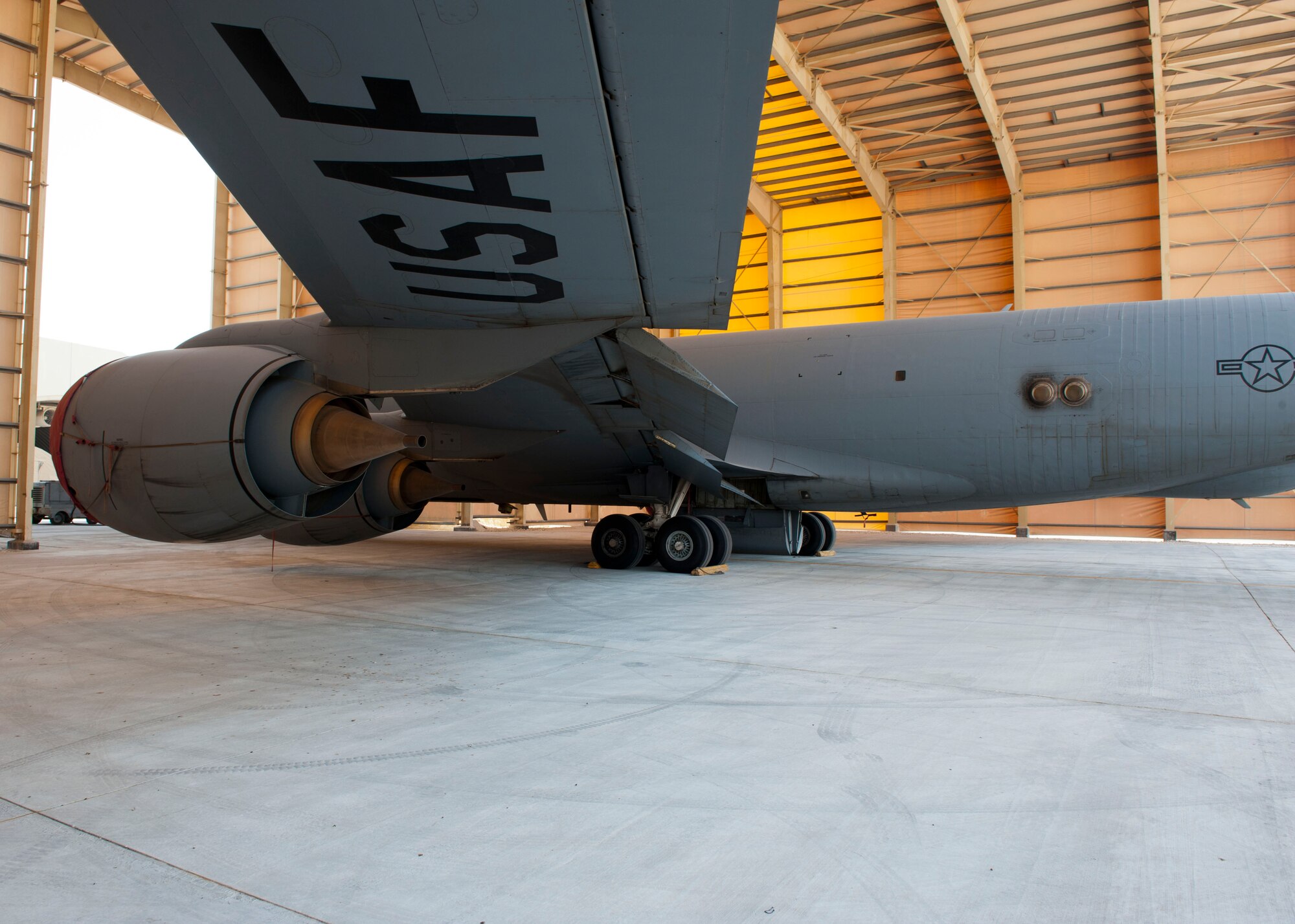 A KC-135 Stratotanker sits underneath a newly constructed awning at Al Udeid Air Base, Qatar, Aug. 22, 2014. The permanent pad which is 40 feet wide by 160 feet long is significant to the maintenance community as it enables Airmen the ability to work on aircraft under the sunshade with protection from direct sunlight, where temperatures can get as hot as 120 degrees in summer. (U.S. Air Force photo by Senior Airman Colin Cates) 