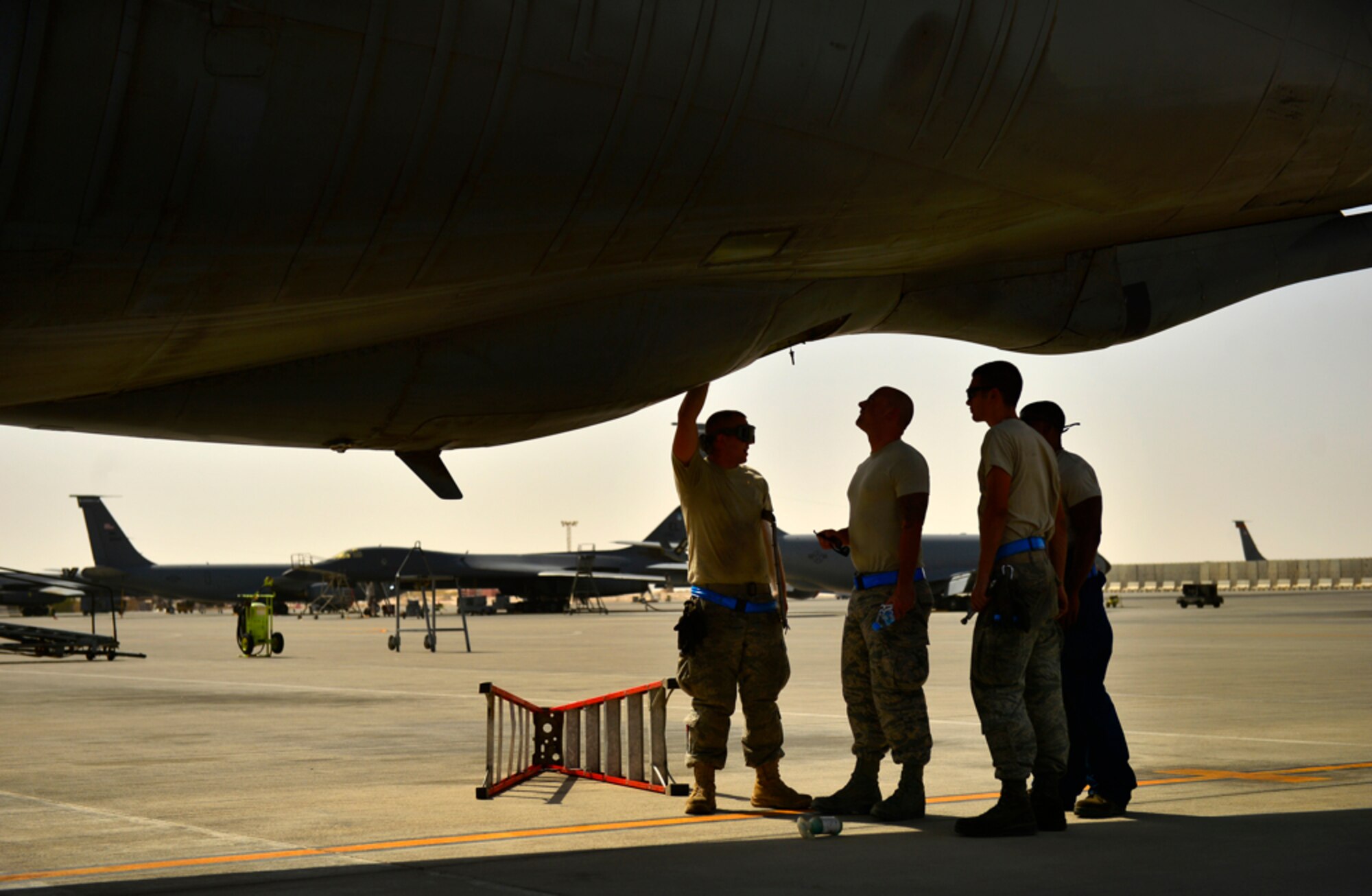 Maintainers assigned to the 340th Expeditionary Aircraft Maintenance Unit, review the boom pod area of the KC-135 Stratotanker, Aug. 5, 2014, Al Udeid Air Base, Qatar. Stratotanker maintainers spend an estimated 24 hours to prepare the aircraft for an in-air refueling mission. (U.S. Air Force photo by Staff Sgt. Vernon Young Jr.)