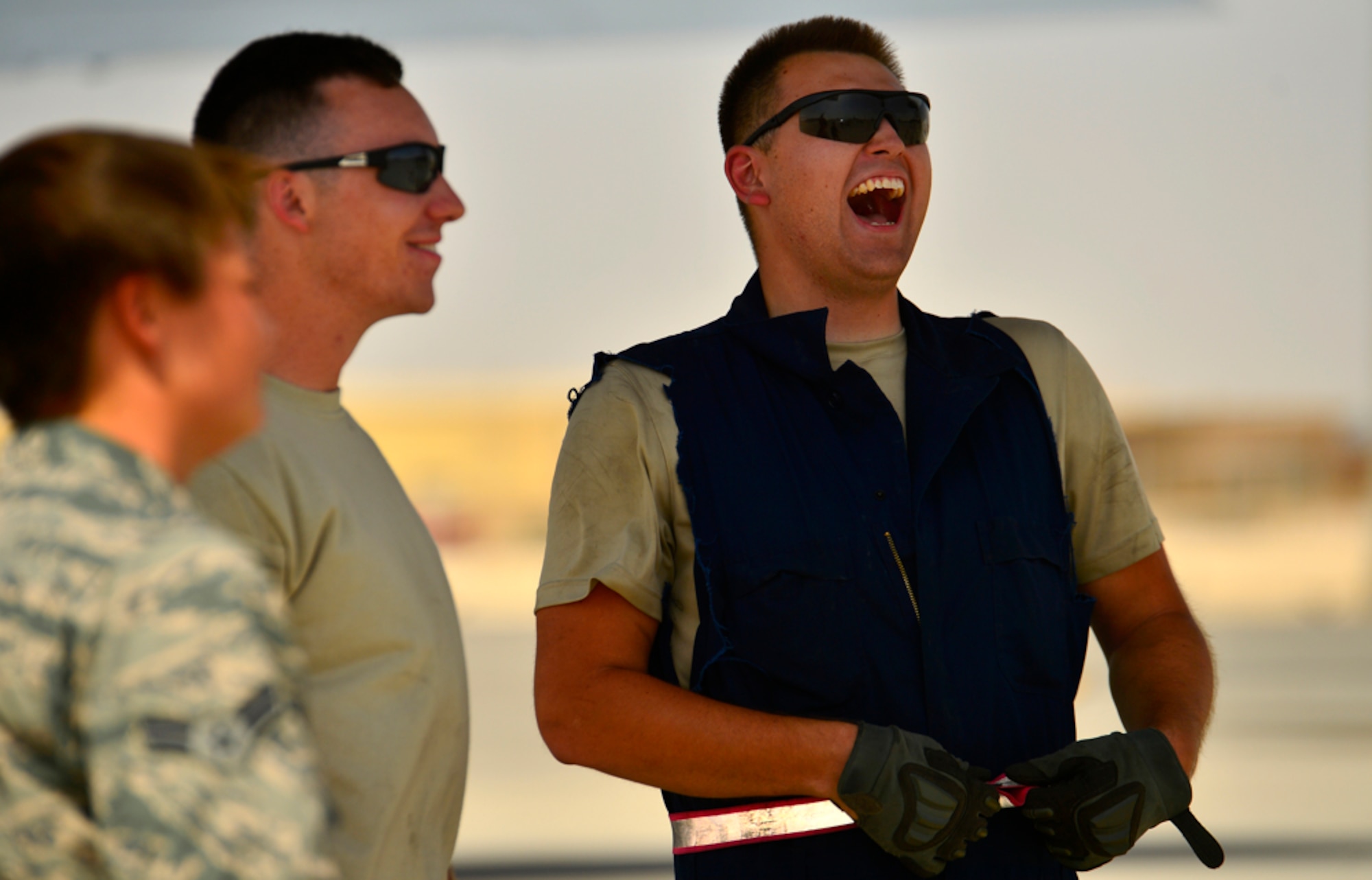 Airman 1st Class Joseph Swartz (right), 340th Expeditionary Aircraft Maintenance Unit KC-135 Stratotanker crew chief, laughs during a break from maintenance duties, Aug. 5, 2014, Al Udeid Air Base, Qatar. Swartz’s subtle New England accent cools the mood with jokes as the work pours in after sorties are flown all over the U.S. Central Command area of responsibility. (U.S. Air Force photo by Staff Sgt. Vernon Young Jr.)