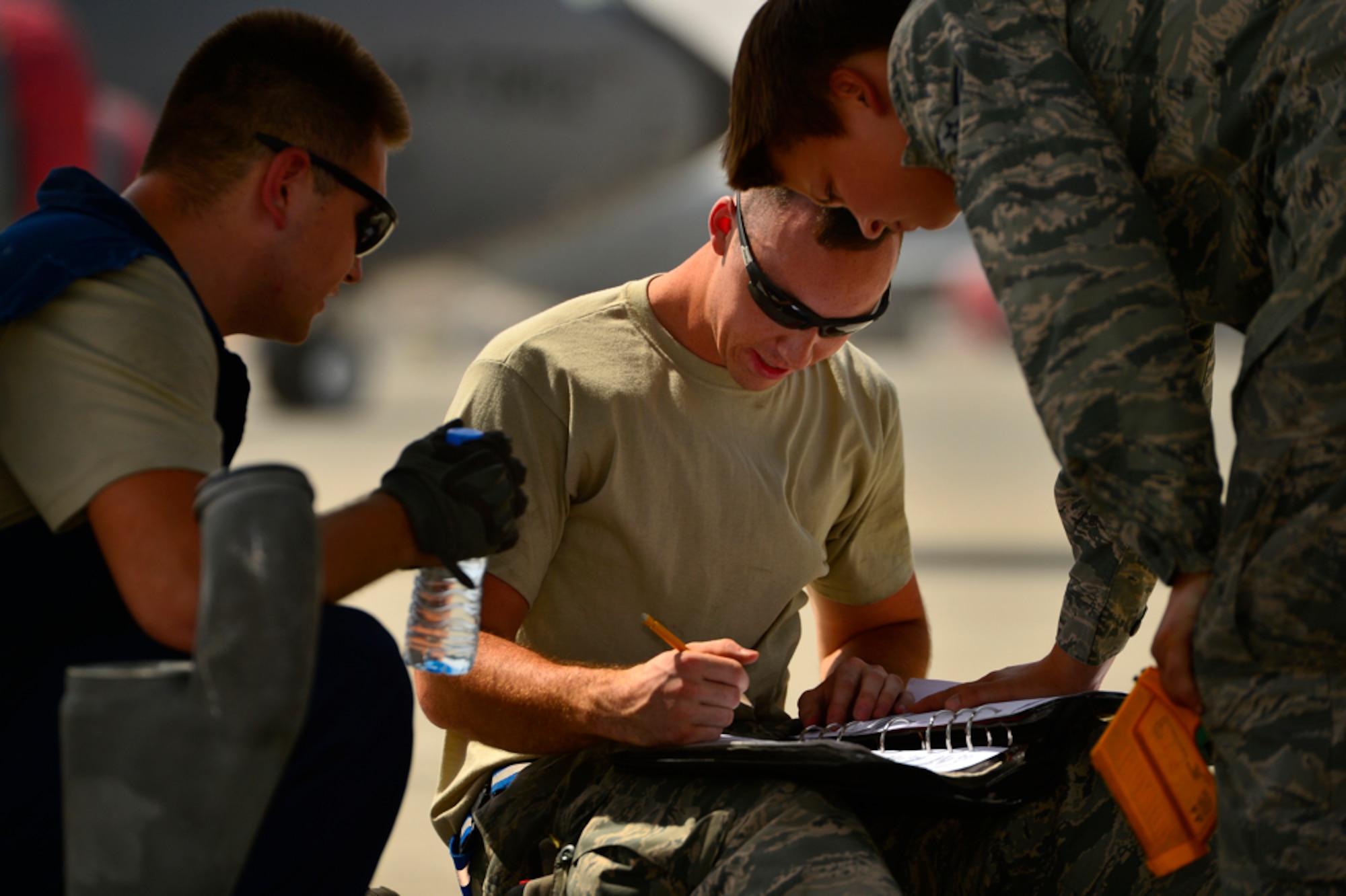 Staff Sgt. Justin Shortt, 340th Expeditionary Aircraft Maintenance Unit KC-135 Stratotanker crew chief, completes a 781A inspection form, Aug. 5, 2014, Al Udeid Air Base, Qatar. The inspection form organizes the maintenance process for Stratotankers maintenance crews to continue maintenance throughout multiple shifts. (U.S. Air Force photo by Staff Sgt. Vernon Young Jr.)