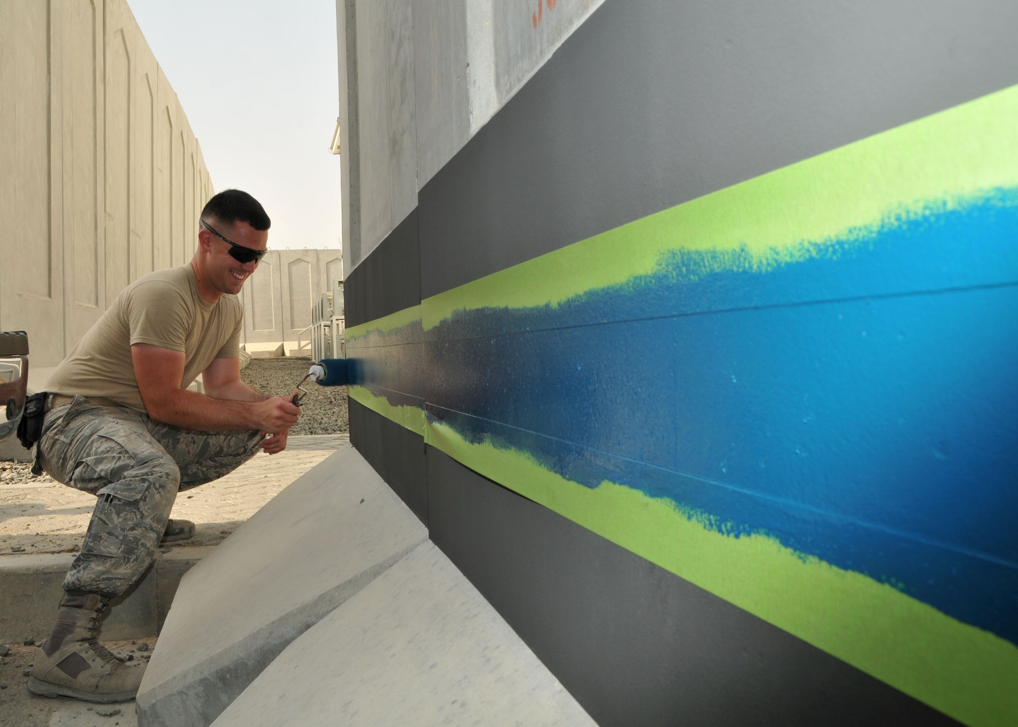 Air Force Senior Airman Mitchell Chesnoski paints a
thin blue line around the security forces compound at the 380th Air Expeditionary Wing at an undisclosed location in Southwest Asia on Aug. 2, 2014. The thin blue line is a symbol of respect and honor for civilian and
military law enforcement members. (U.S. Air National Guard photo by Senior Master Sgt. Eric Peterson/Released)
