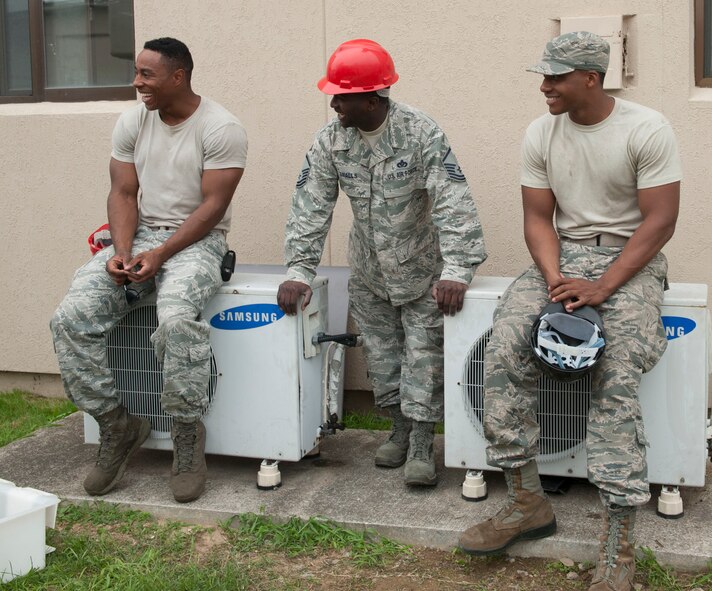 Senior Airman Chaz Wilson, Senior Airman Steven William, 51st Civil Engineer Squadron heating, ventilation, air condition and refrigeration journeymen, and Master Sgt. Octavius Smalls, 51st CES NCO in charge of HVAC-R, share a laugh during a break at Osan Air Base, Republic of Korea, Aug. 14, 2014. During breaks, members of the shop tell jokes to pass the time. (U.S. Air Force photo by Senior Airman Matthew Lancaster) 

