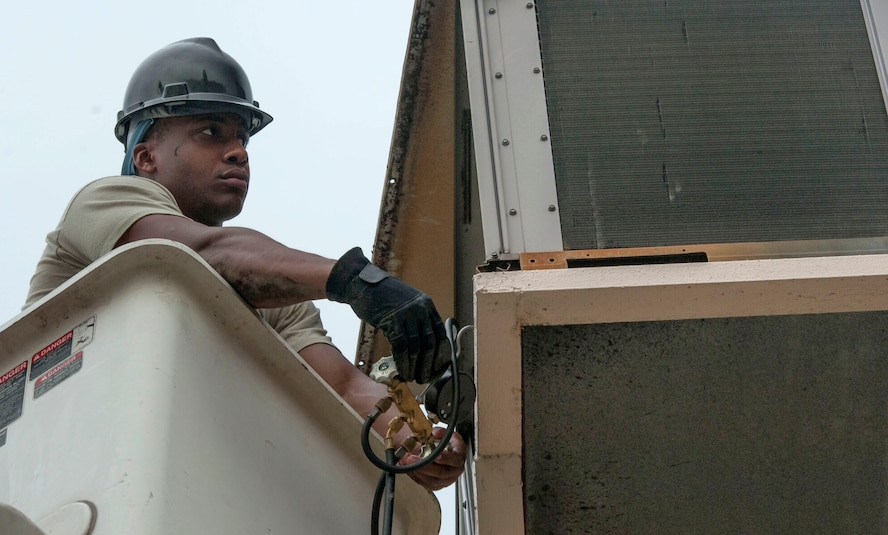 Senior Airman Steven Williams, 51st Civil Engineer Squadron heating, ventilation, air condition and refrigeration journeyman, performs maintenance on an AC unit at Osan Air Base, Republic of Korea, Aug. 14, 2014. The HVAC shop is in charge of making sure all the AC units on base are working properly. (U.S. Air Force photo by Senior Airman Matthew Lancaster) 

