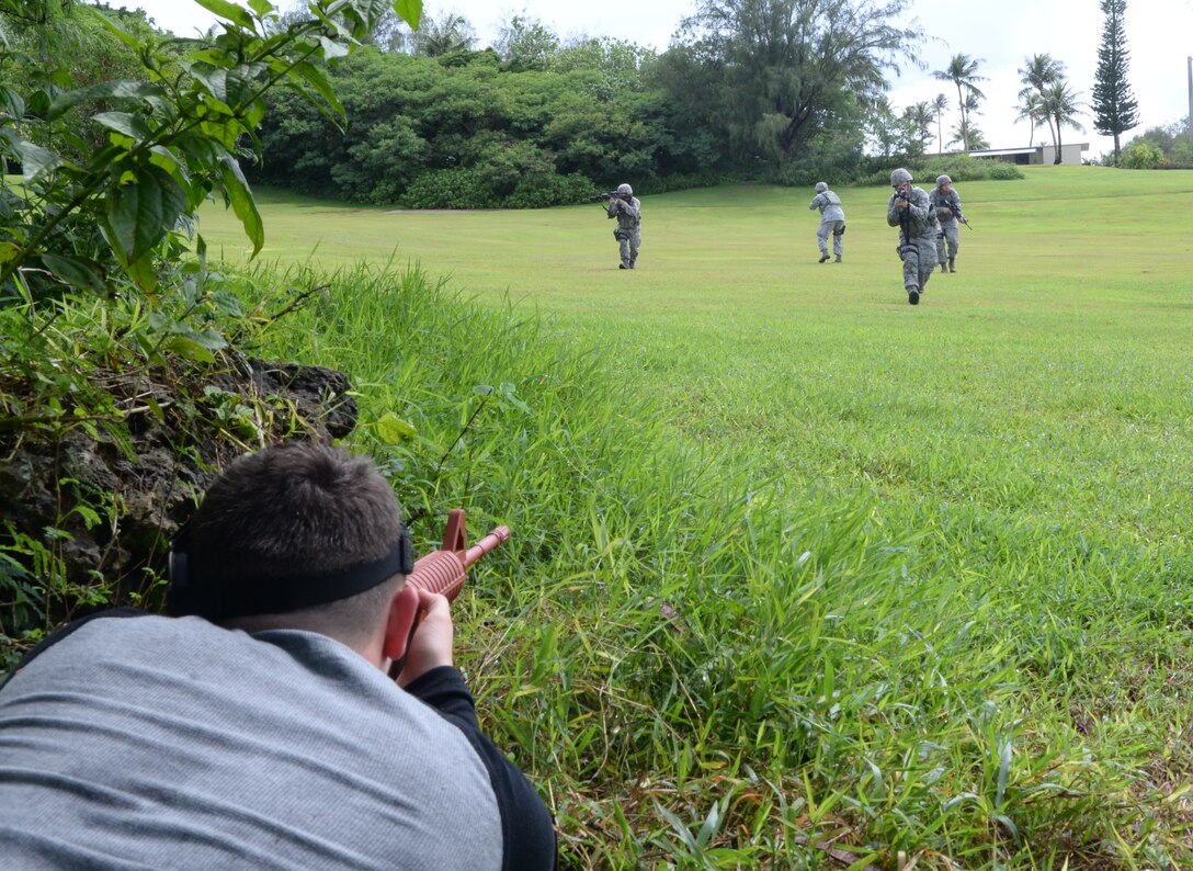 Airmen from the 36th Security Forces Squadron defend the base from opposing forces played by members of Team Andersen during Exercise Beverly Palm 14-04 on Aug. 20, 2014, on Andersen Air Force Base, Guam. The 12-hour exercise took place to enhance the skills of Airmen in preparation for real-world contingencies. (U.S. Air Force photo by Airman 1st Class Amanda Morris/Released)