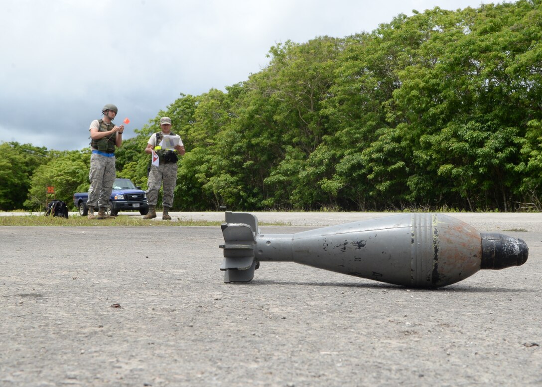 Senior Airman Jesus Babauta, and Airman 1st Class Brandon Levulis, both with the 36th Munitions Squadron munitions storage area, identify a simulated unexploded ordnance during Exercise Beverly Palm 14-04 Aug. 20, 2014, on Andersen Air Force Base, Guam. The 12-hour exercise took place to enhance the skills of Airmen in preparation for real-world contingencies. (U.S. Air Force photo by Airman 1st Class Amanda Morris/Released)