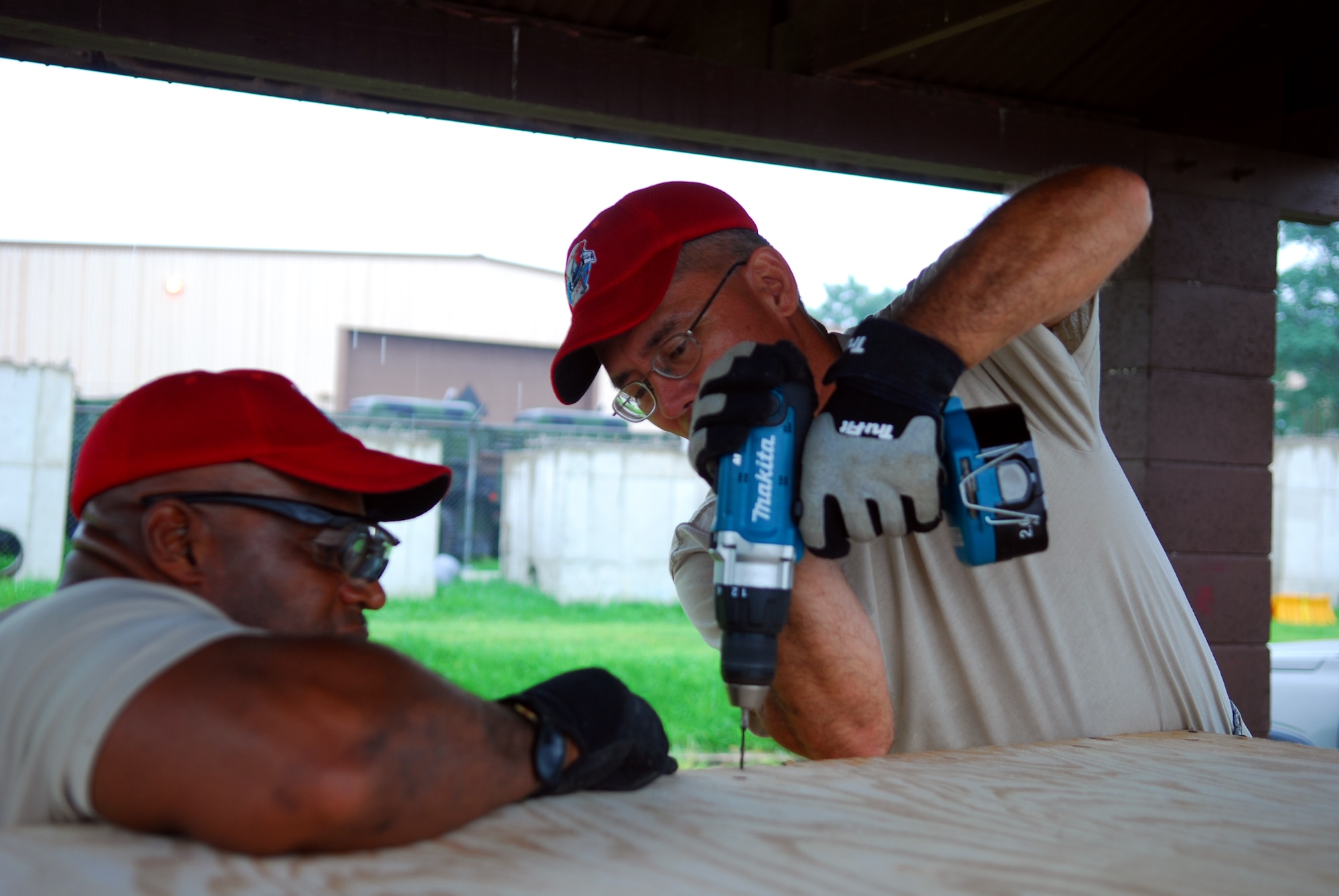 Master Sgt. Roberto Pitter and Tech. Sgt. Edward Mendiola, 254th RED HORSE squadron members, build an air conditioner deflector at Rush Park, Osan Air Base, South Korea, during the Ulchi Freedom Guardian exercise, Aug. 13, 2014. RED HORSE personnel helped create a home away from home for UFG participants. (U.S. Air Force photo by Senior Airman Racheal E. Watson/Released)	