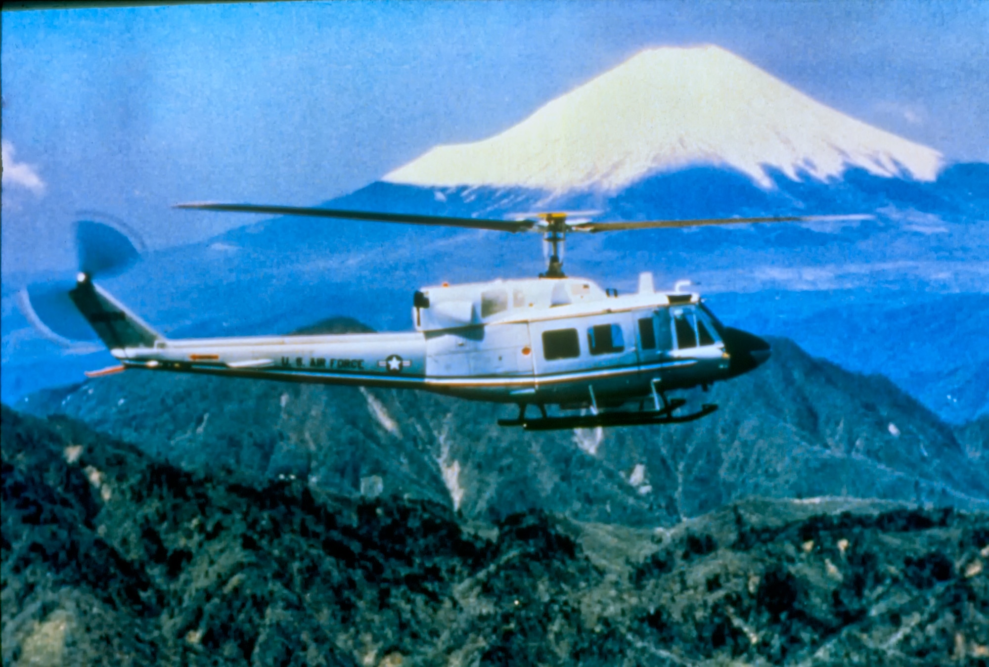 A UH-1 Huey helicopter flew near Mt. Fuji, Japan, 1980s. (U.S. Air Force photo courtesy of 374th Airlift Wing History office)