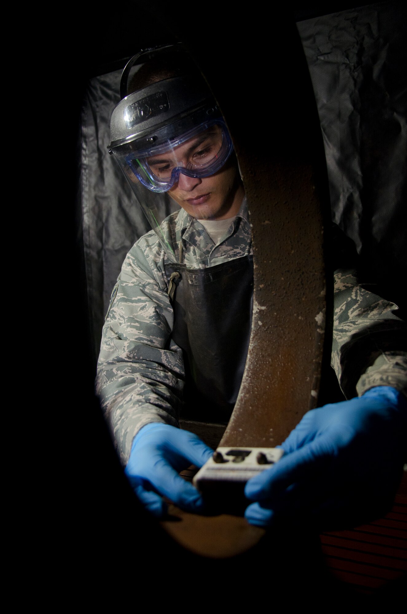 Airman 1st Class Ashton Surber, 36th Maintenance Squadron non-destructive inspection journeyman, uses a magnetic particle machine to search for defects during an aircraft part inspection  Aug. 21, 2014, on Andersen Air Force Base, Guam. NDI Airmen provide support to the structural maintenance program, which ensures air and space equipment are safe, serviceable and in mission-ready condition. (U.S. Air Force photo by Senior Airman Katrina M. Brisbin/Released)