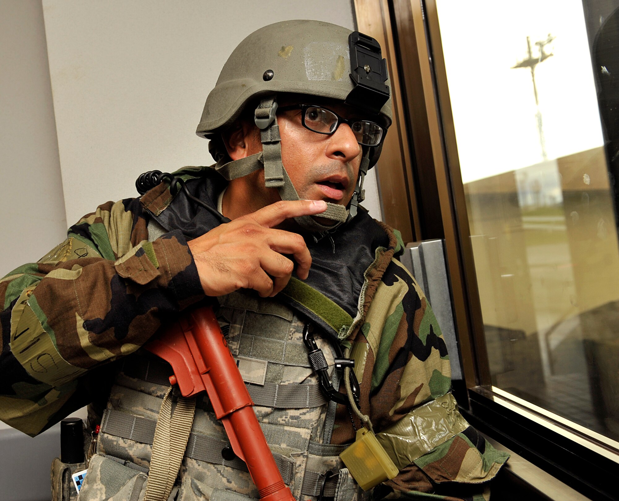 U.S. Air Force Master Sgt. Michael Guzman, 18th Security Forces Squadron flight chief, checks to see if the area outside of the 733rd Air Mobility Squadron Passenger Terminal is clear during a mission focused exercise on Kadena Air Base, Japan, Aug. 21, 2014. 18th SFS personnel participated in the MFE to stay prepared for real-world contingencies. (U.S. Air Force photo by Naoto Anazawa/Released)