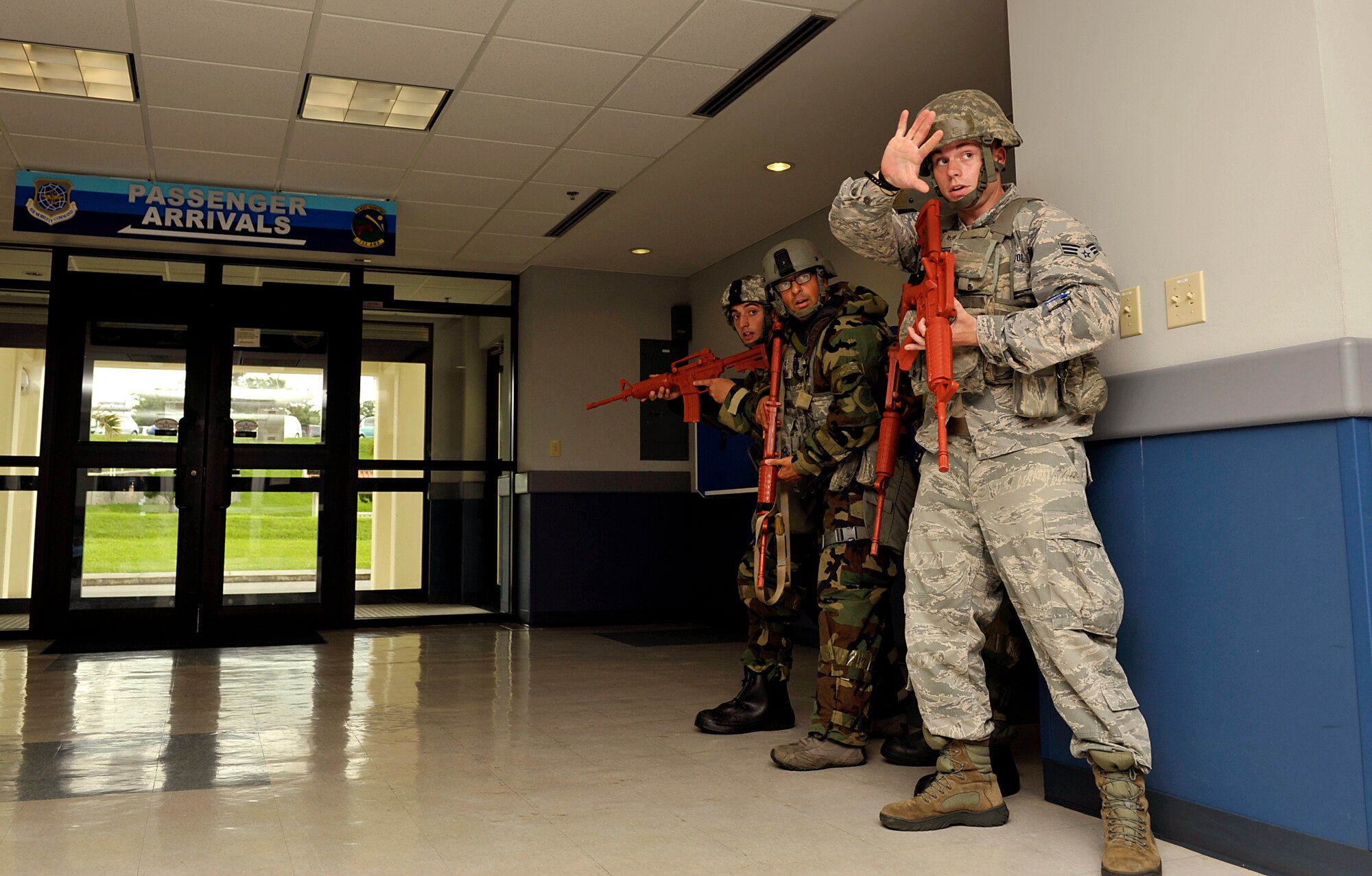 U.S. Air Force Senior Airman Ian Watson, 18th Security Forces Squadron patrolman, directs members with hand signals during a mission focused exercise on Kadena Air Base, Japan, Aug. 21, 2014. Members of the 18th SFS responded to an scenario where opposing forces broke on the base and tried to take over the 733rd Air Mobility Squadron Passenger Terminal. (U.S. Air Force photo by Naoto Anazawa/Released)