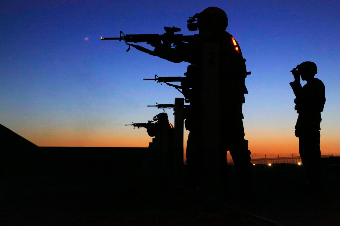 U.S. Marine Sgt. Lonnie Smith Jr., right, observes as U.S. Marines engage targets while using night-vision goggles and advanced target pointers during night training at a range on Camp Bastion in Afghanistan's Helmand province, Aug. 19, 2014. Smith is a flight equipment technician assigned to Heavy Helicopter Squadron 366.