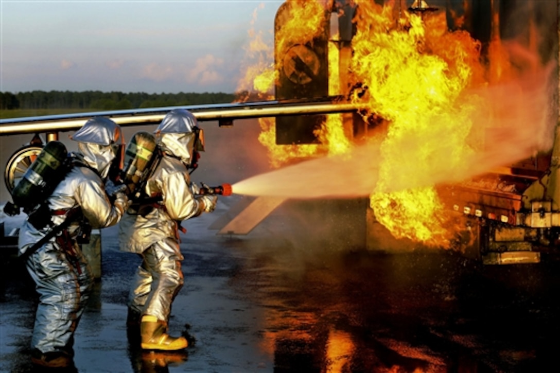 Marine Cpl. Kyle James, left, and Marine Sgt. Ruben Ochoa battle an aircraft fire during aircraft rescue and firefighting training on Marine Corps Air Station Cherry Point, N.C., Aug. 14, 2014. James and Ochoa are firefighting specialists assigned to Headquarters Squadron. 