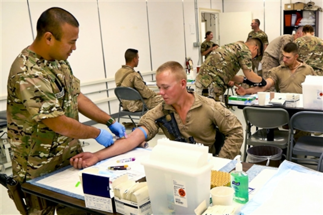 U.S. sailors draw blood from U.S. Marines during a walking blood bank on Camp Leatherneck in Helmand province, Afghanistan, Aug. 14, 2014.