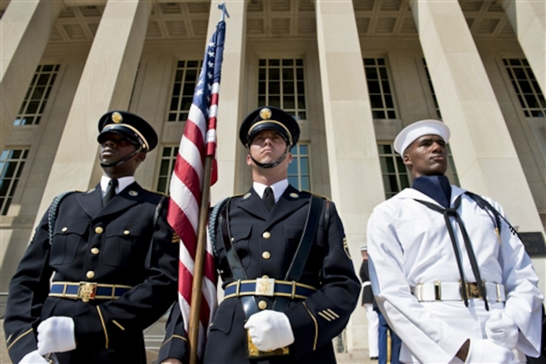 embers of the honor guard stand at attention before welcoming Singaporean Chief of Defense Force Lt. Gen. Ng Chee Meng to the Pentagon, Aug. 21, 2014. U.S. Army Gen. Martin E. Dempsey, chairman of the Joint Chiefs of Staff, hosted an honor cordon before meeting with his counterpart to discuss issues of mutual importance. 