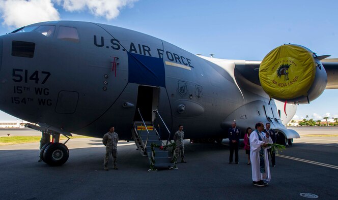 Reverend Kahu Kordell Kekoa addresses the crowd before giving a traditional Hawaiian blessing to a 535th Airlift Squadron C-17 Globemaster III Aug. 20, 2014, on the flightline at Joint Base Pearl Harbor-Hickam, Hawaii. During the ceremony, the C-17 was dedicated to the memory of local and national hero and Medal of Honor recipient Sen. Daniel Inouye. (U.S. Air Force photo/Tech. Sgt. Terri Paden)