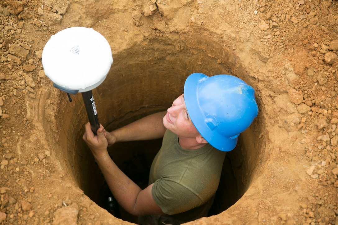 Lance Cpl. Kyle T. Davis, a Berwick, Pennsylvania, native, measures the depth of a hole during the construction of an obstacle course Aug. 14 on Camp Hansen. Davis familiarized himself with a GPS system, which measures the area of construction with accuracy of up to one millimeter. The construction of the obstacle course helps Marines stay proficient with equipment that is not commonly used, according to Davis. Davis is a combat engineer with 9th Engineer Support Battalion, 3rd Marine Logistics Group, III Marine Expeditionary Force. 