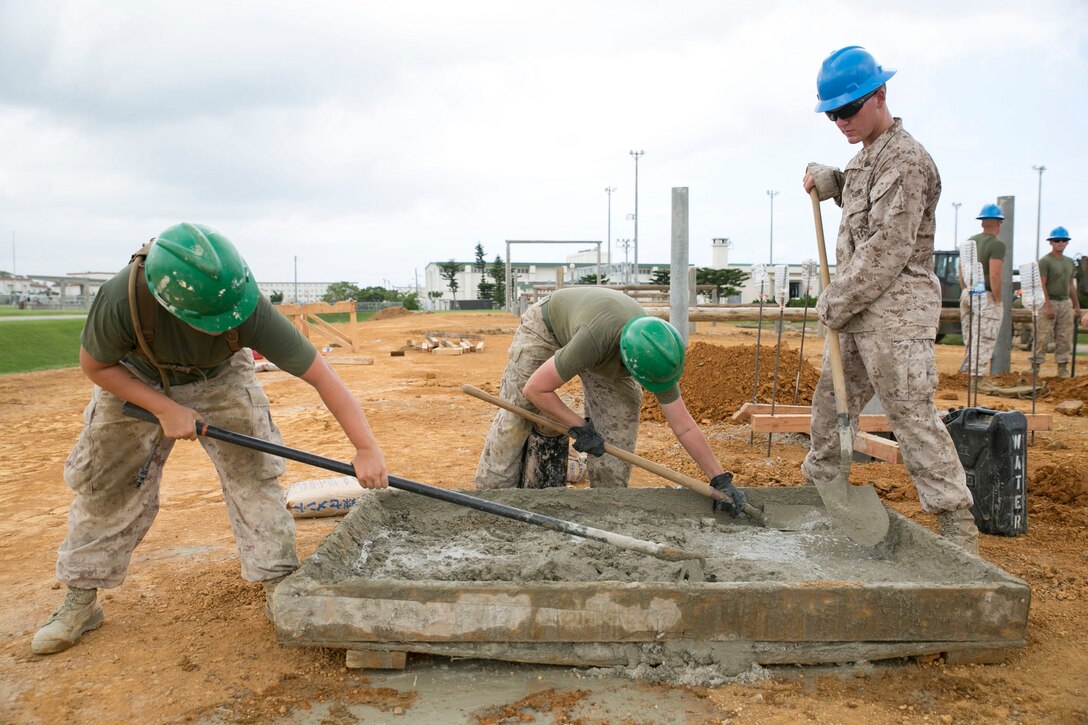 Lance Cpls. Summer L. Alvarez, left, Kirsten M. Rotton, center, and Cpl. Taylor R. Tingey mix concrete during the construction of an obstacle course Aug. 14 on Camp Hansen. The new obstacle course replaces the old one ensuring safe and effective training. An upcoming ceremony will signify the official opening of the updated obstacle course in mid-September. The Marines are combat engineers with 9th Engineer Support Battalion, 3rd Marine Logistics Group, III Marine Expeditionary Force. 