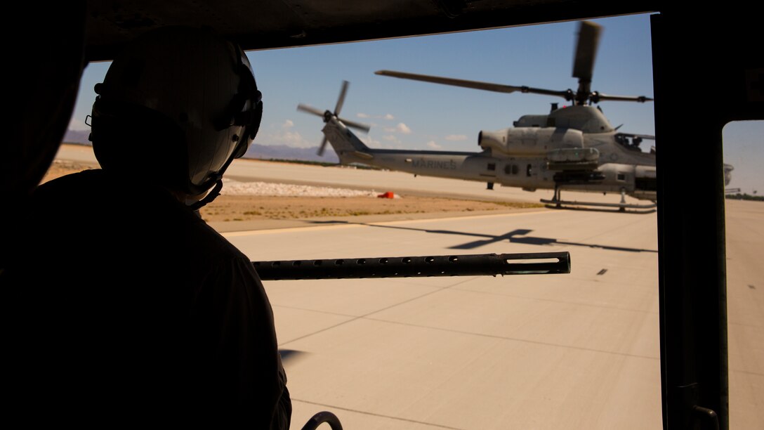 Lance Cpl. Austin Shephard, a crew chief with Marine Light Helicopter Squadron 369, based at Marine Corps Base Camp Pendleton, Calif., and an Anacoco, La., native, looks out the open door of a UH-1Y Venom helicopter as it rises above the flight line of Marine Corps Air Station Yuma, Arizona, Wednesday, Aug. 20, 2014. The helicopter was heading toward the Yodaville Urban Target Complex, located in the Barry M. Goldwater Range, Ariz., to conduct a moving target exercise.