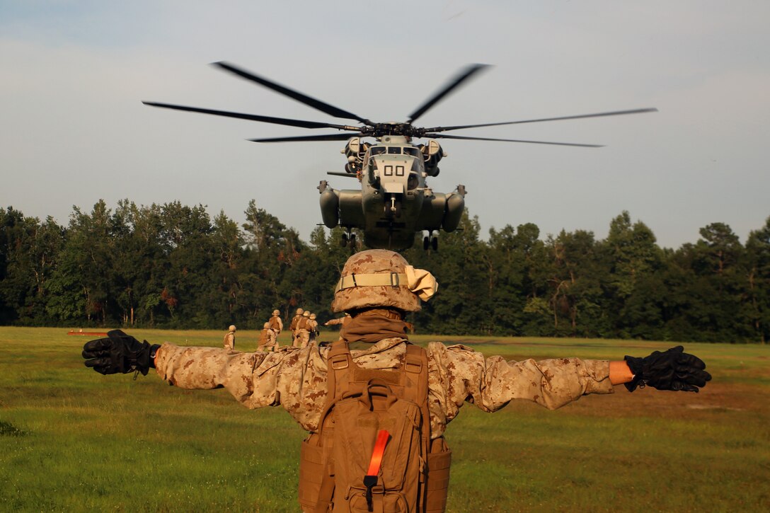 Private First Class Corey Sullivan, a landing support specialist with Transportation Support Company, Combat Logistics Battalion 6, 2nd Marine Logistics Group guides a CH-53E Super Stallion during helicopter support team operations at a field exercise aboard Marine Corps Base Camp Lejeune, N.C., Aug. 20, 2014. The HST operation allowed landing support Marines to gain valuable experience.