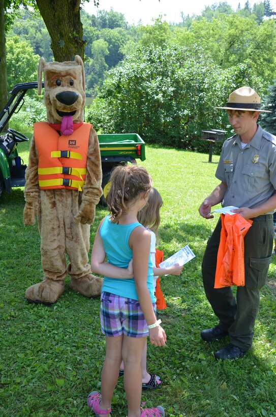 Bobber the water safety dog and park ranger Brad Labadie talk water safety with children at Eau Galle Recreation Site in Spring Valley, Wis., July 11, 2014. 