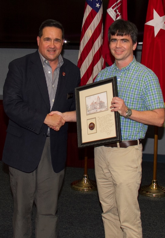 Mississippi Valley Division Commander Brig. Gen. Duke DeLuca presents ERDC's Gary Brown with a framed print and coin in appreciation for work on Mississippi River Hydrodynamic and Delta Management Study. 