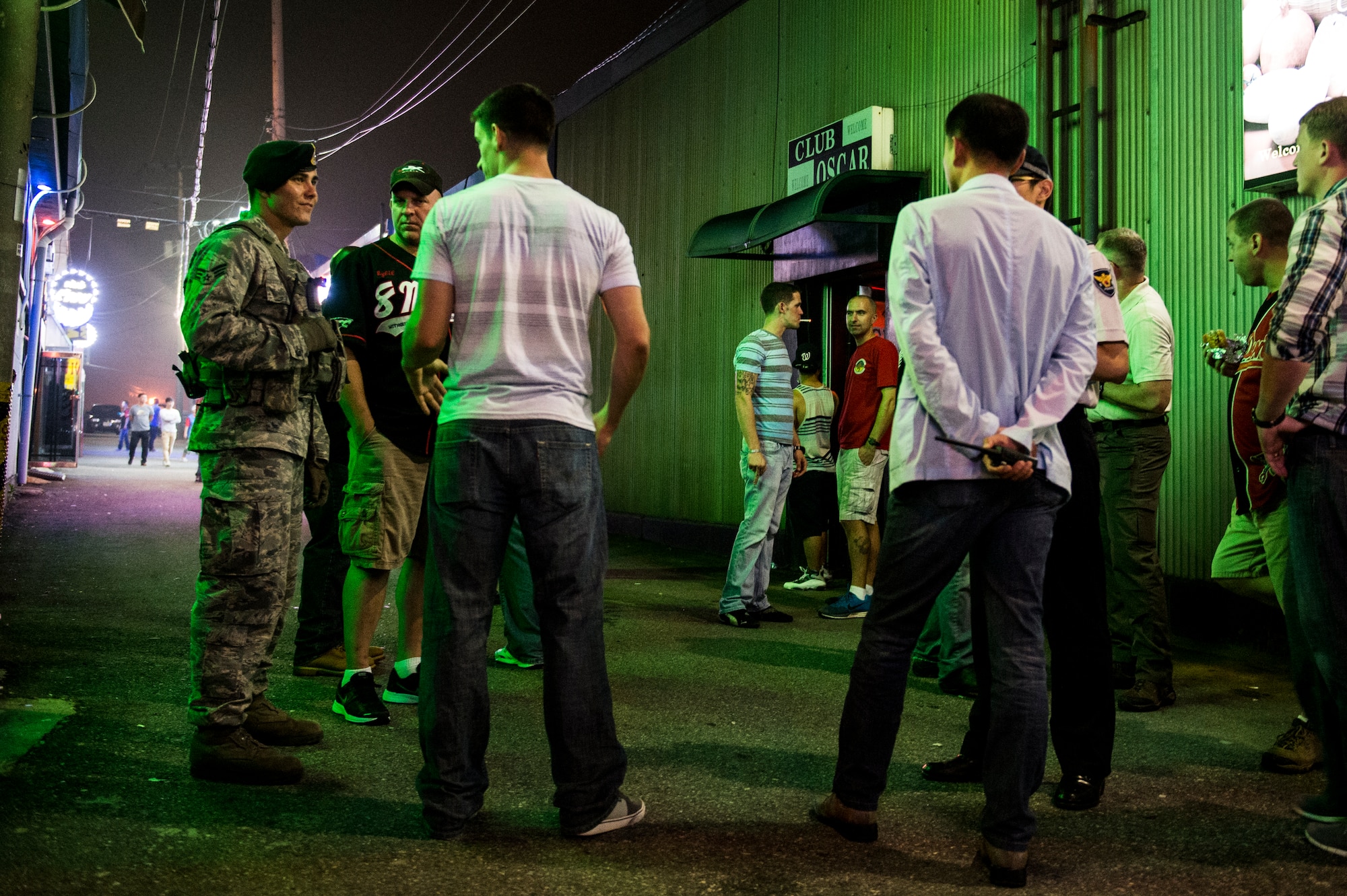 U.S. Air Force Senior Airman Tony Wilson, 8th Security Forces Squadron response force leader, talks with Airmen from the 8th Civil Engineer Squadron in America Town outside of Kunsan Air Base, Republic of Korea, Aug. 22, 2014. The 8th SFS conducts town patrols on the weekends to remind Airmen to be safe and make smart choices. (U.S. Air Force photo by Staff Sgt. Stephany Richards/ Released)