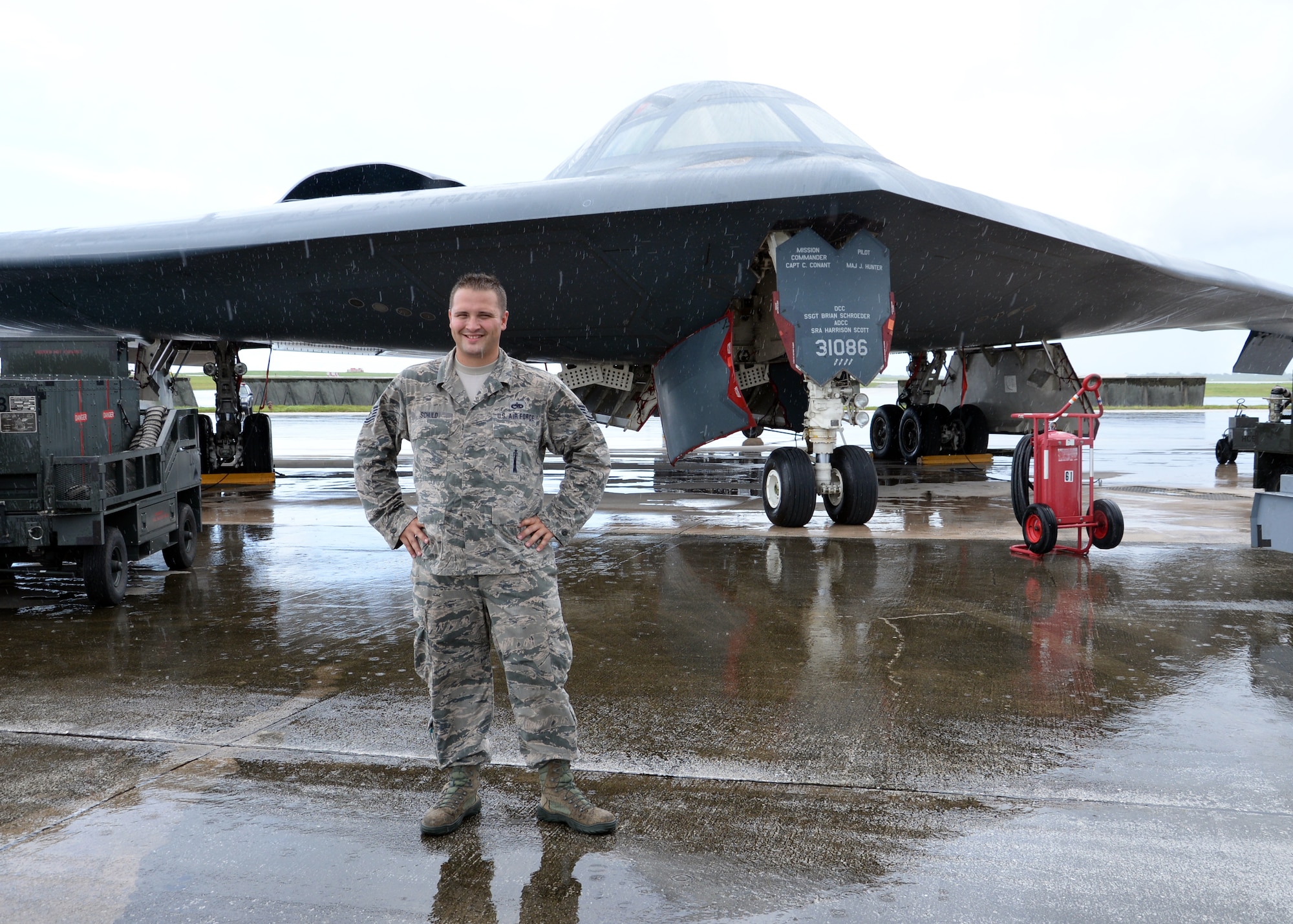 U.S. Air Force Tech Sgt. Brock Schuld, 131st Aircraft Maintenance Squadron maintainer, poses in front of a B-2 Spirit bomber during a deployment, Andersen Air Force Base, Guam, Aug. 22, 2014.  The bombers and approximately 200 support Airmen, assigned to the 509th Bomb Wing at Whiteman Air Force Base, Mo., deployed to Guam Aug. 6, 2014 to improve combat readiness and ensure regional stability.  Bomber deployments help maintain stability in the region while allowing units to become familiar with operating in the theater according to USPACOM.  (U.S. Air Force photo by Senior Airman Cierra Presentado/Released)
