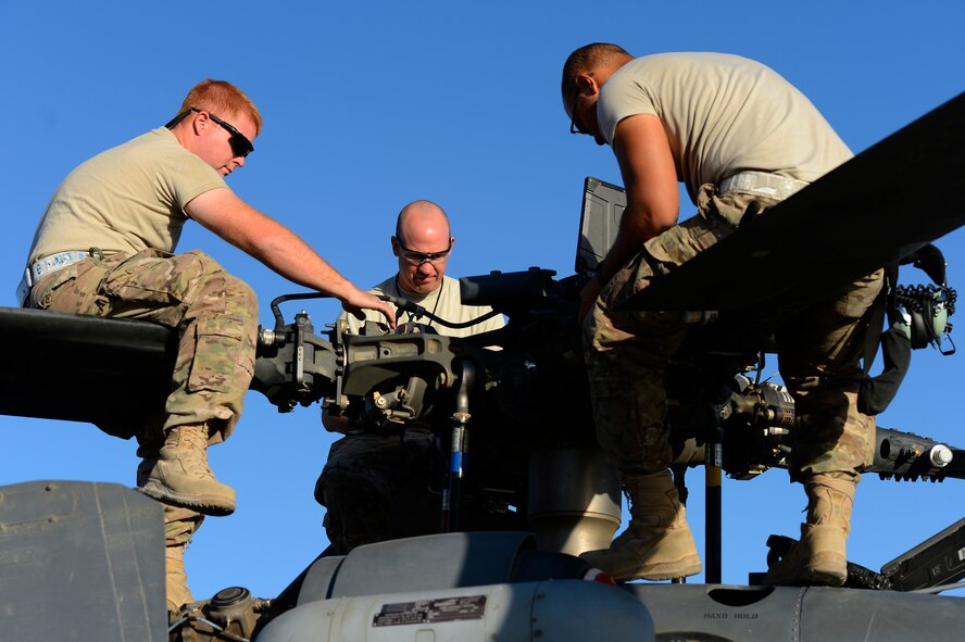 U.S. Air Force Senior Airman Benjamin Martin, Tech. Sgt. Korey Ehinger, and Senior Airman LeSean Young-Dilworth, 455th Expeditionary Aircraft Maintenance Squadron, perform a preflight inspection on a HH-60G Pave Hawk at Bagram Air Field, Afghanistan, July 19, 2014. Martin is a Colorado Springs, Colo. native, Ehinger is a Ft. Wayne, Ind. native, and Young-Dilworth is a Pembroke Pines, Fla. native. All are deployed from the 923rd Aircraft Maintenance Squadron, Davis-Monthan Air Force Base, Ariz. (U.S. Air Force photo by Senior Airman Sandra Welch)