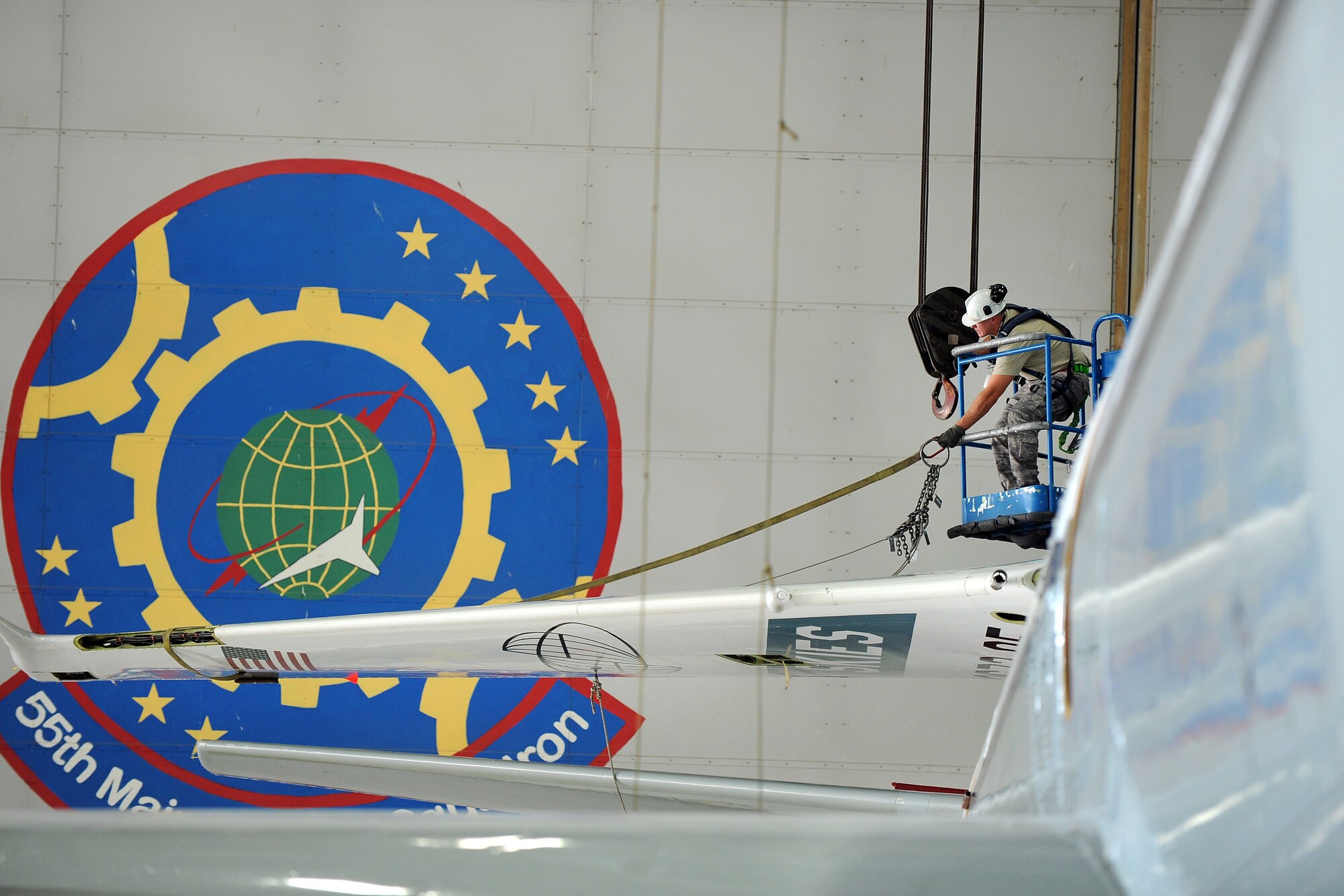 U.S. Air Force Staff Sgt. Chris Gothberg, an aircraft repair technician assigned to the 55th Maintenance Squadron, removes the strap used to fold the tail of an OC-135B Open Skies aircraft inside of the Bennie Davis Maintenance Faciliy at Offutt Air Force Base, Neb.  The tail was folded to make way for sheet metal repair.  (U.S. Air Force photo by Josh Plueger/Released)