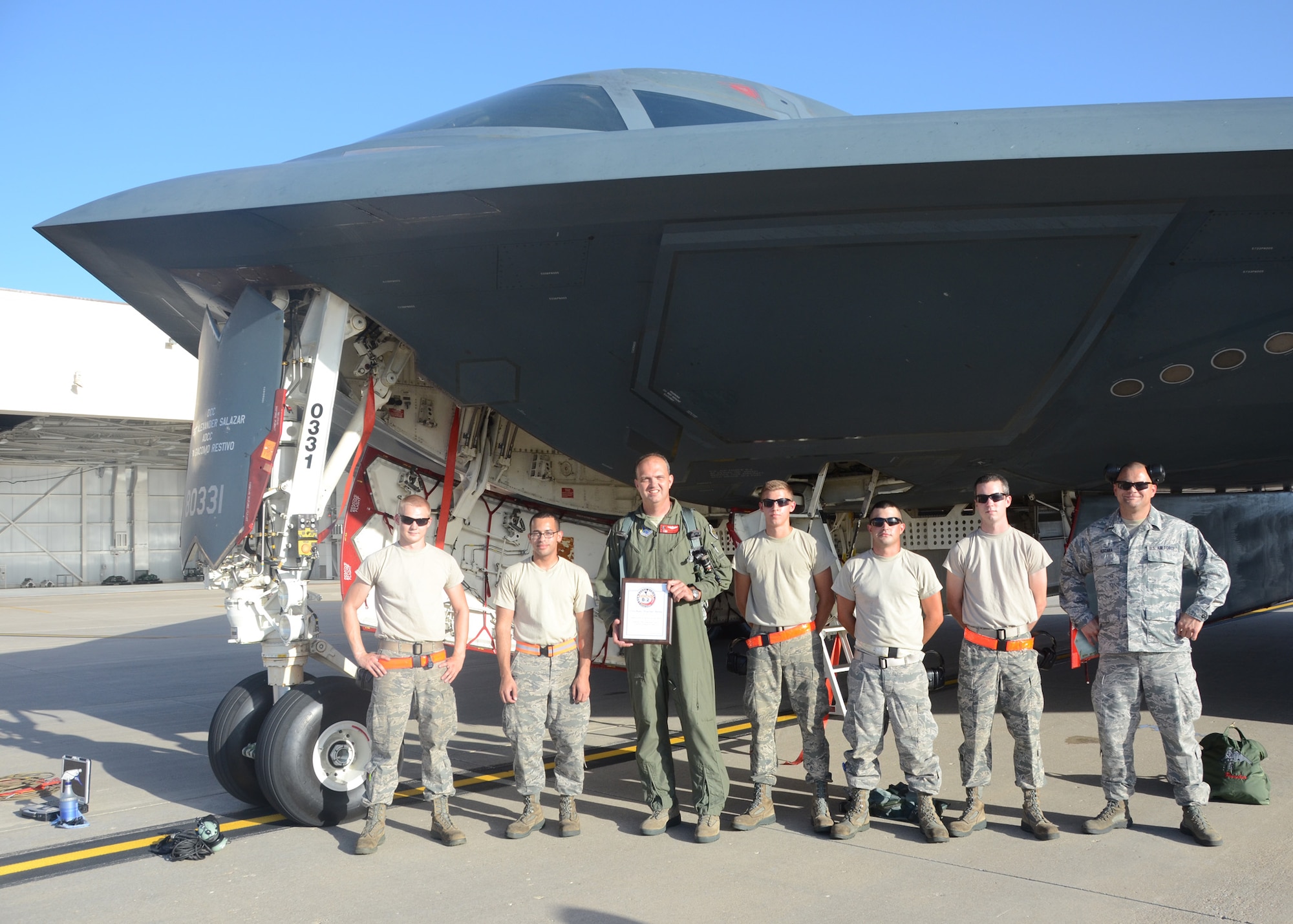 After passing his 1000 flying-hour milestone in the B-2, Lt. Col. Ryan Bailey, 131st Bomb Wing, Missouri Air National Guard, stands proudly with members of the 131 Maintenance Group at Whiteman Air Force Base, August 23, 2014. “Today’s flight is about the superb maintenance Airmen in the 131st and 509th Bomb Wings,” Bailey said. “It’s really a 100,000-hour flight because it takes well over 100 hours of great maintenance for every flight hour.” Pictured l to r:  Sr. Airman Robert Hawkins III, Sr. Airman Christopher Frye, Lt. Col. Ryan Bailey, Airman 1st Class Ethan Davis, Sr. Airman Jesse Moore, Airman 1st Class Colter Laucks and Master Sgt. Craig Kuzara.  (U.S. Air National Guard photo by Staff Sgt. Brittany Cannon/ RELEASED)