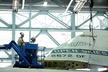U.S. Air Force Staff Sgt. Chris Gothberg and Tech Sgt. Russel Orr watch as the tail of an OC-135B Open Skies aircraft is folded to make room for sheet metal repairs inside of the Bennie Davis Maintenance Facility at Offutt Air Force Base, Neb.  The Open Skies aircraft is a non-weaponized airframe used for observation support of the Open Skies Treaty that is comprised of 34 countries.  (U.S. Air Force photo by Josh Plueger/Released)