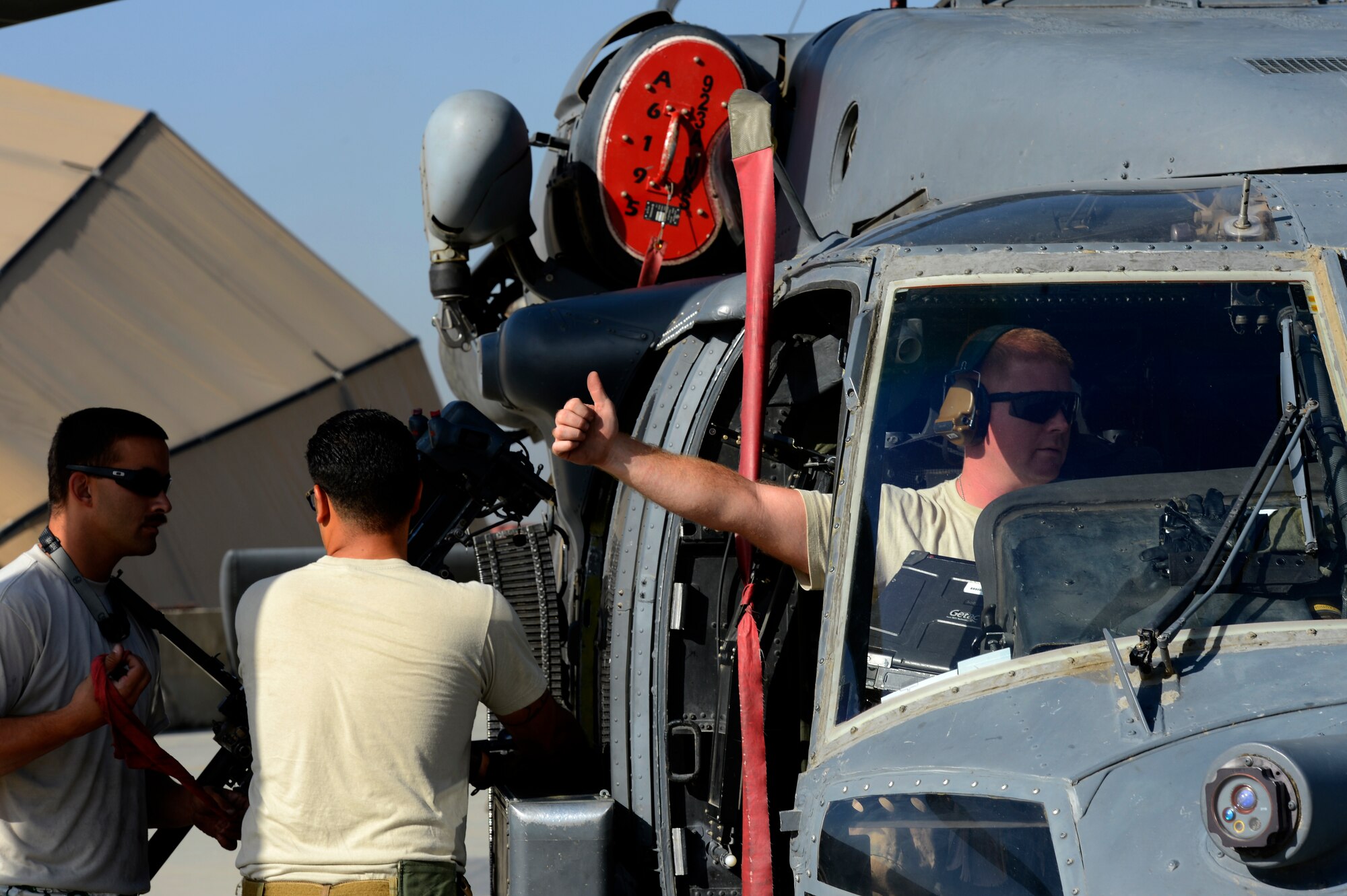 Senior Airman Benjamin Martin, 455th Expeditionary Aircraft Maintenance Squadron crew chief, gives a thumbs-up during a preflight inspection on an HH-60G Pave Hawk helicopter at Bagram Air Field, Afghanistan, July 10, 2014. Martin, a Colorado Springs, Colorado native, is deployed from the 923rd Aircraft Maintenance Squadron, Davis-Monthan Air Force Base, Arizona. (U.S. Air Force photo by Senior Airman Sandra Welch/Released)